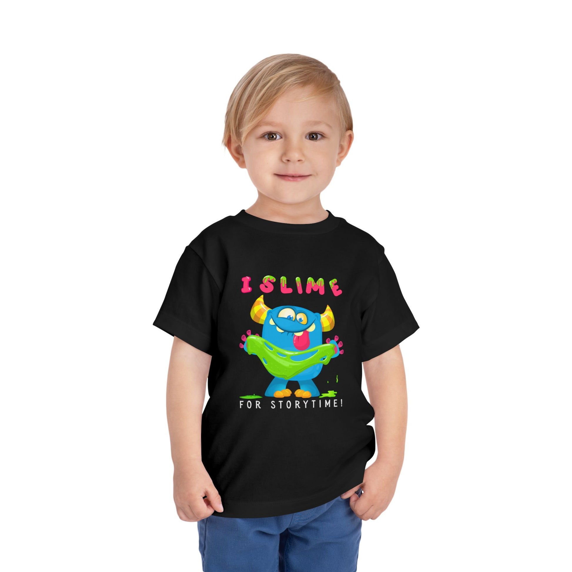 Child wearing a black toddler t-shirt with a colorful monster graphic holding green slime and playful text 'I SLIME FOR STORYTIME!'