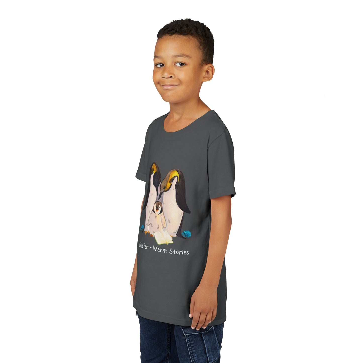 Boy waring a gray t-shirt with a penguin family, open book and text 'Cold Feet - Warm Stories'