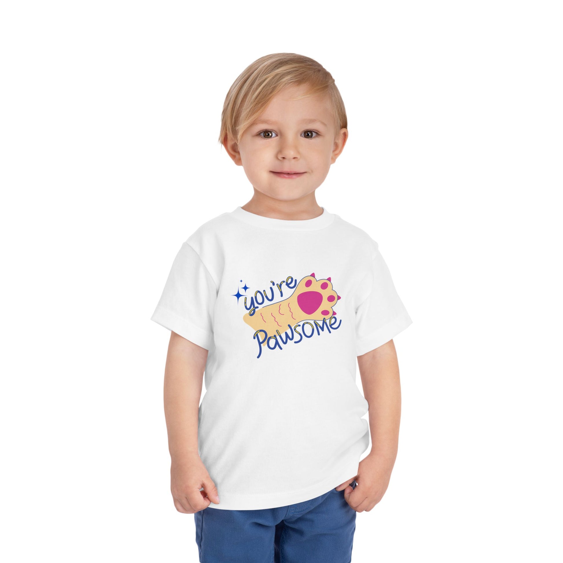 Toddler wearing a white t-shirt with 'you're pawsome' text and paw print design