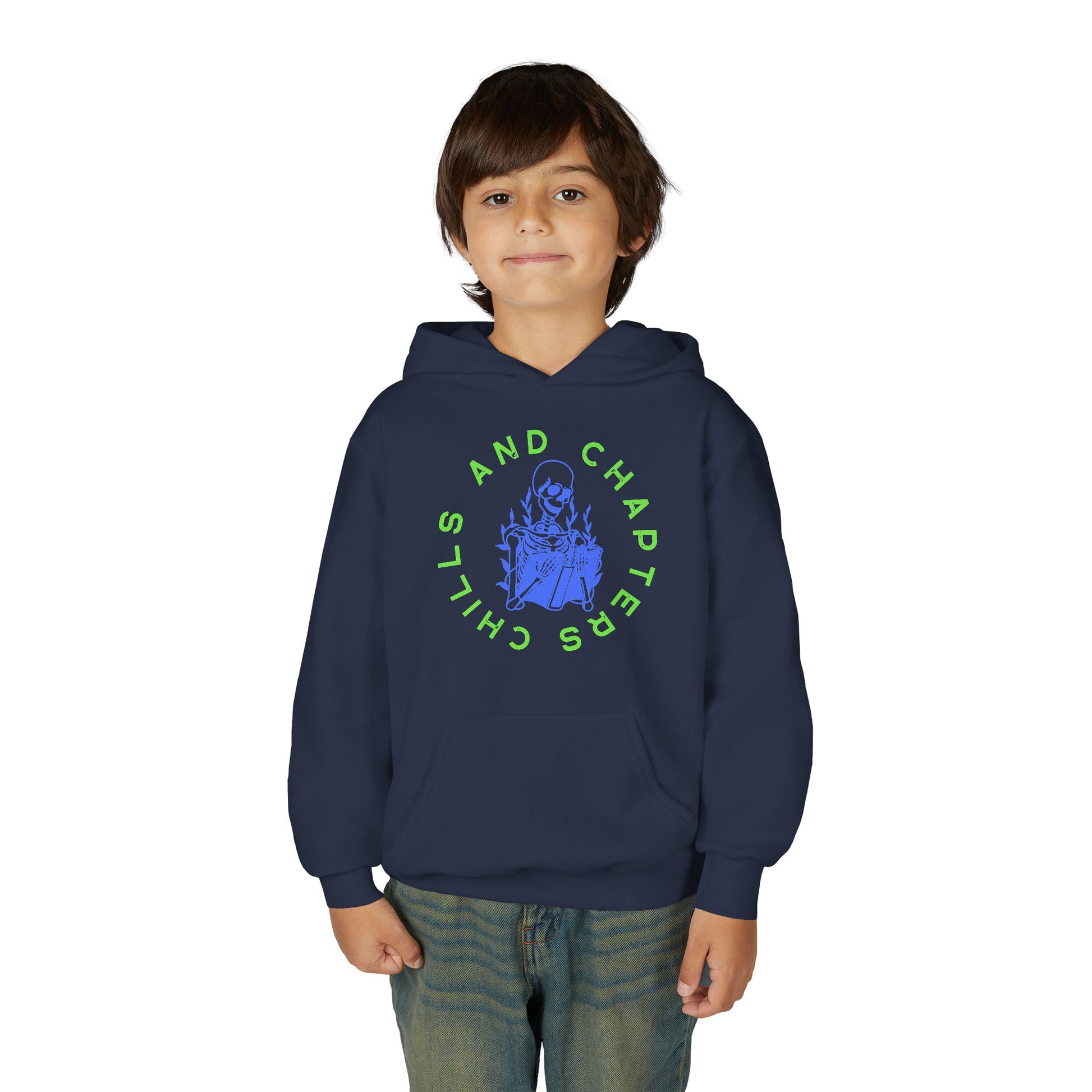 Boy wearing a navy blue hoodie with a skeleton reading a book graphic design and circular text 'CHILLS AND CHAPTERS'