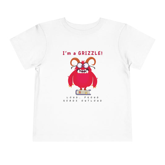 White toddler personality t-shirt with a red monster graphic standing on a book proudly proclaiming 'I'm a GRIZZLE!' Sub-text 'Loud, Proud, Reads Aloud.'