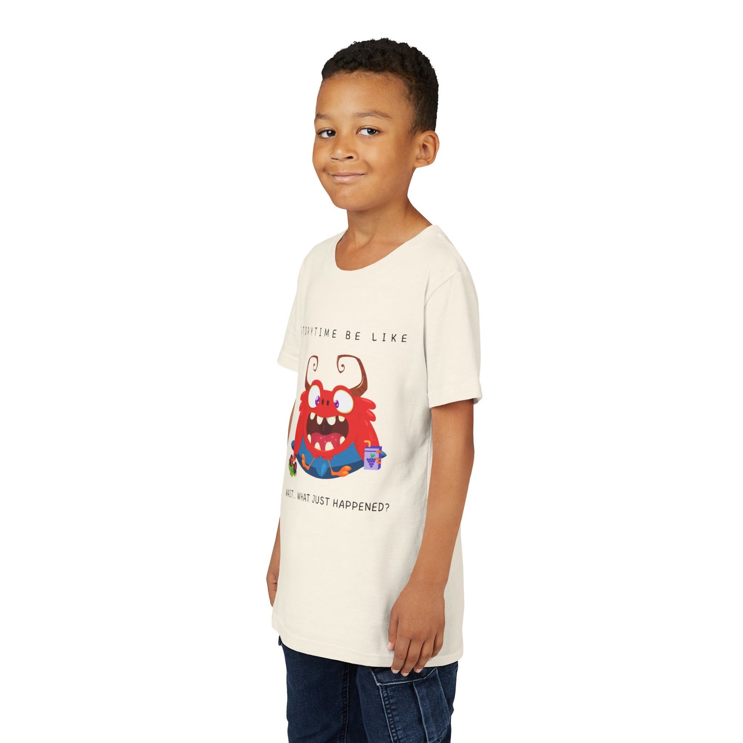 Boy wearing a beige t-shirt with a bewildered cartoon monster graphic sitting on a pillow, holding a car toy and a juice box, text 'Storytime be like wait...what just happened?'