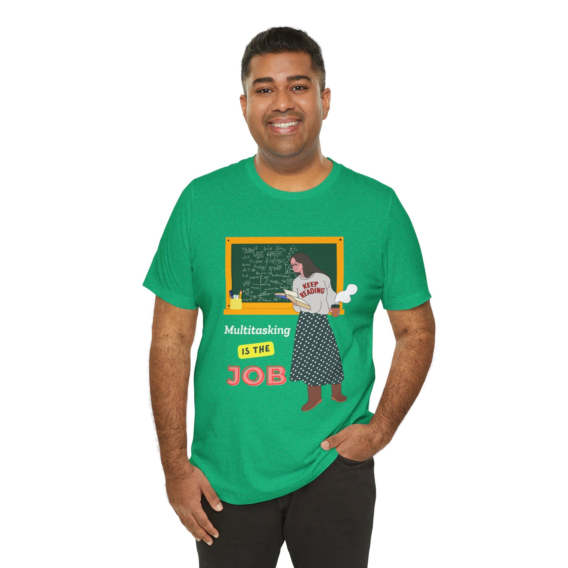 Man wearing a green t-shirt with a graphic design of a woman at a chalkboard, an open book in one hand and steaming coffee in the other, text 'Multitasking is the Job' 