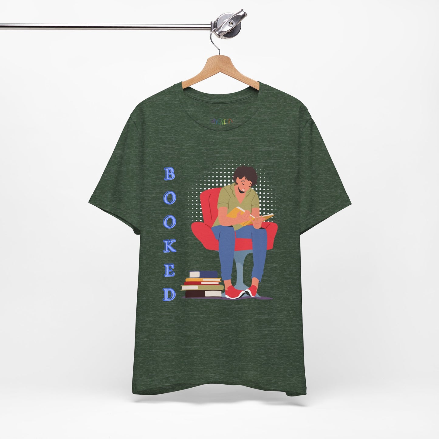 Heather forest t-shirt with a graphic of a person sitting in a chair, reading a book, a stack of books at his feet and text 'BOOKED' 