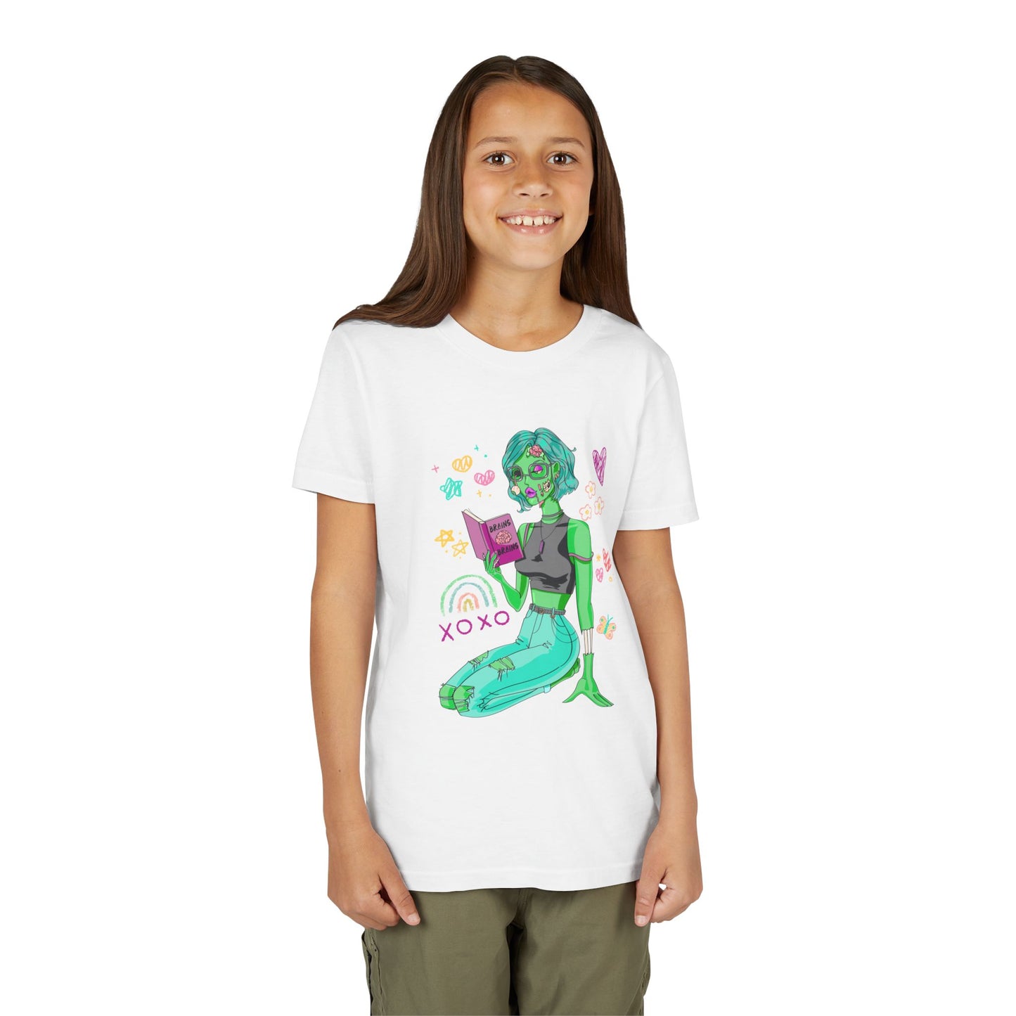 Girl wearing a white t-shirt with a girl zombie reading a book, surrounded by colorful doodles