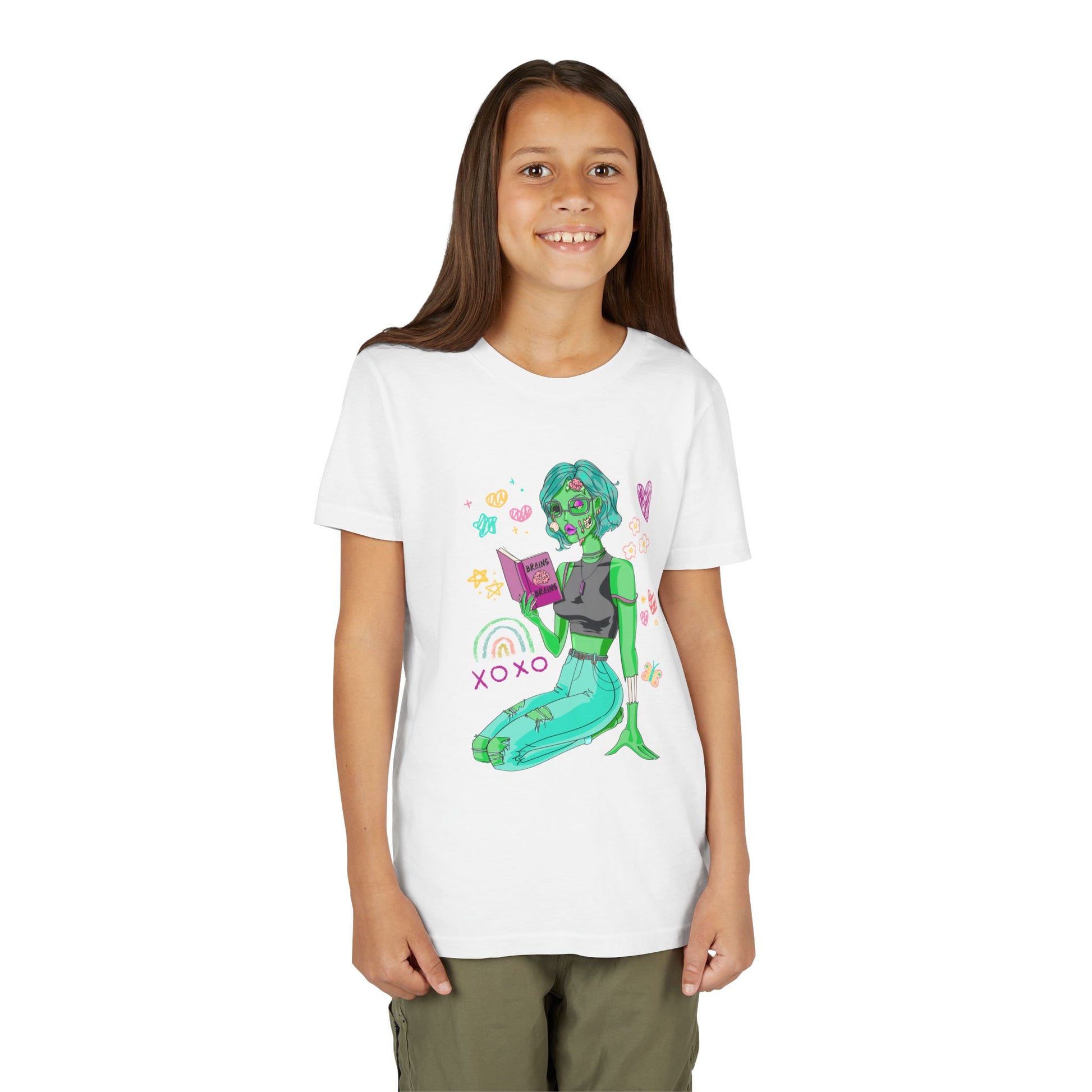 Girl wearing a white t-shirt with a girl zombie reading a book, surrounded by colorful doodles