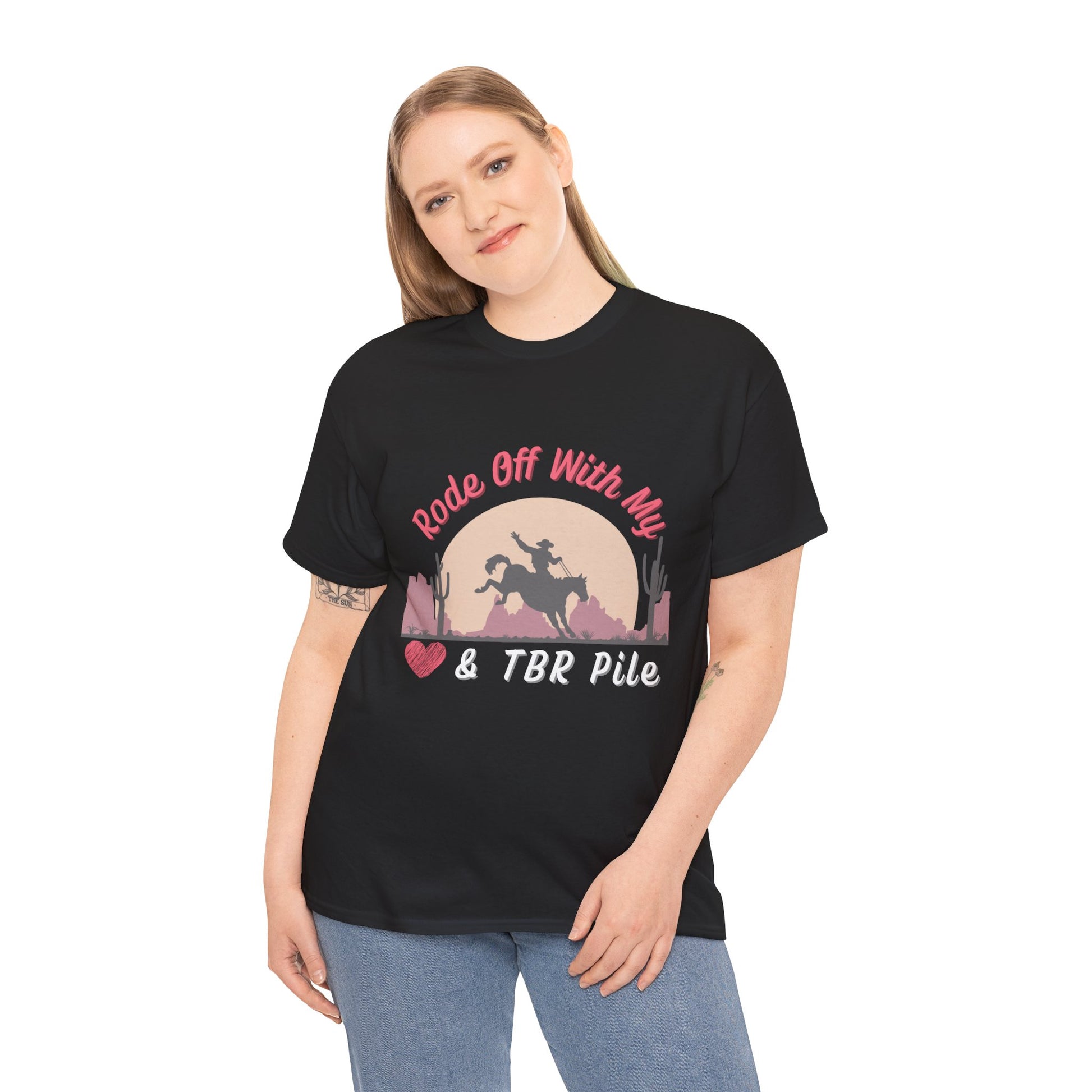 Woman wearing a black t-shirt with soft dessert sunset and a cowboy on a horse, text 'Rode Off With My Heart & TBR Pile'