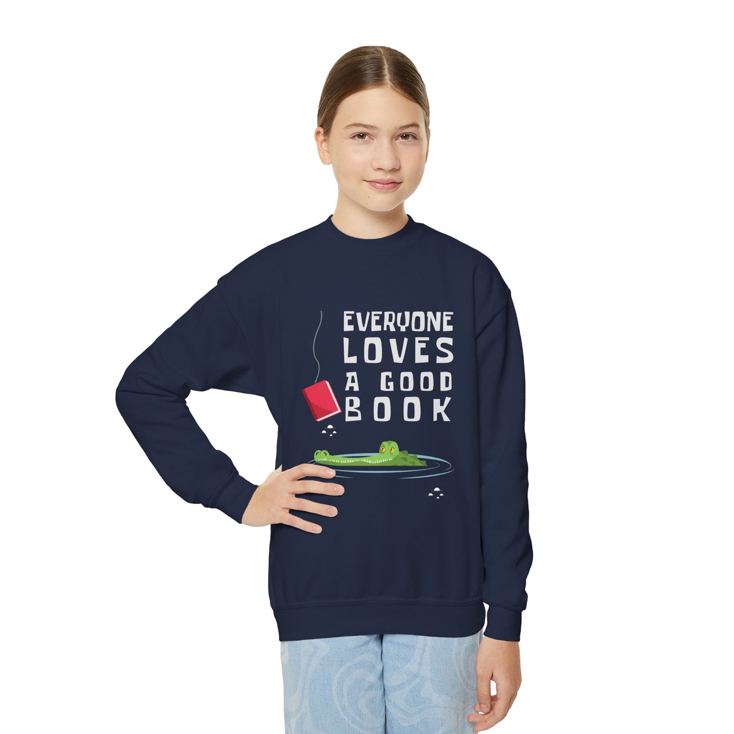 Girl wearing a navy blue sweatshirt with a of an alligator looking at a book on a hook and text 'everyone loves a good book'