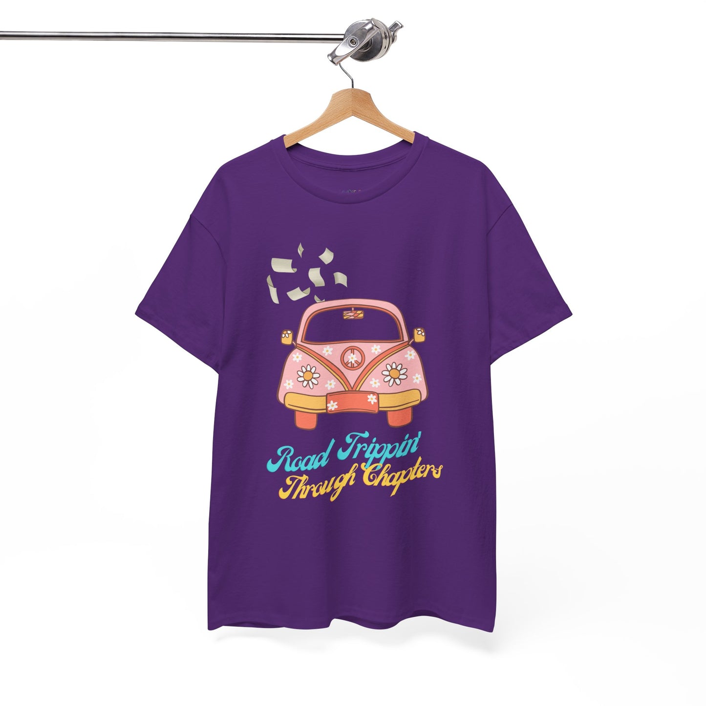Purple t-shirt with a retro pink car , pages flying out the windows and text 'Road Tripping Through Chapters' 