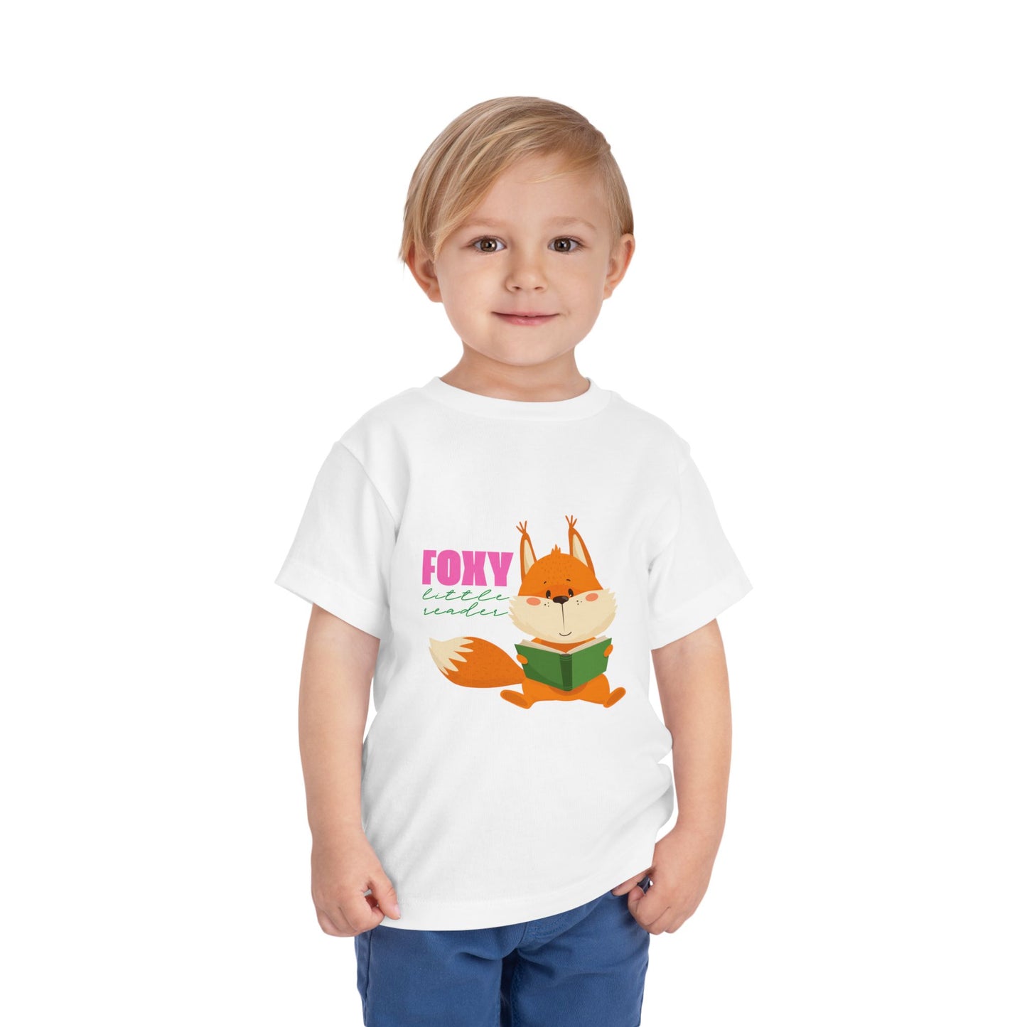 Child wearing a white toddler t-shirt with a fox reading a book graphic and 'Foxy Little Reader' text 