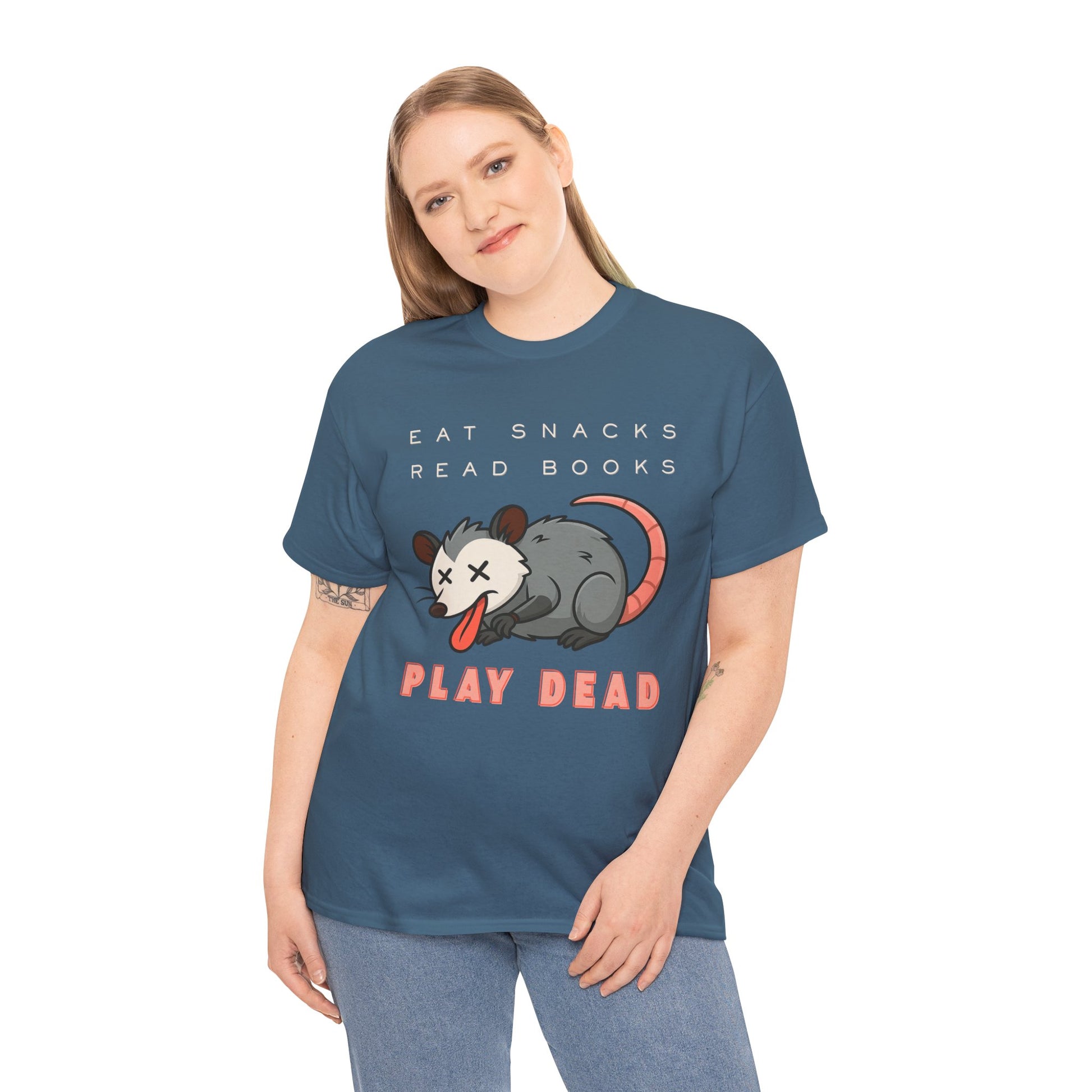 Woman wearing a teal t-shirt with an opossum graphic and text 'Eat Snacks. Read Books. Play Dead.'