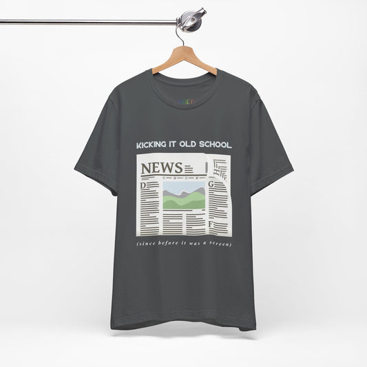 Gray t-shirt with a newspaper graphic and text 'Kicking It Old School (since before it was a screen)'