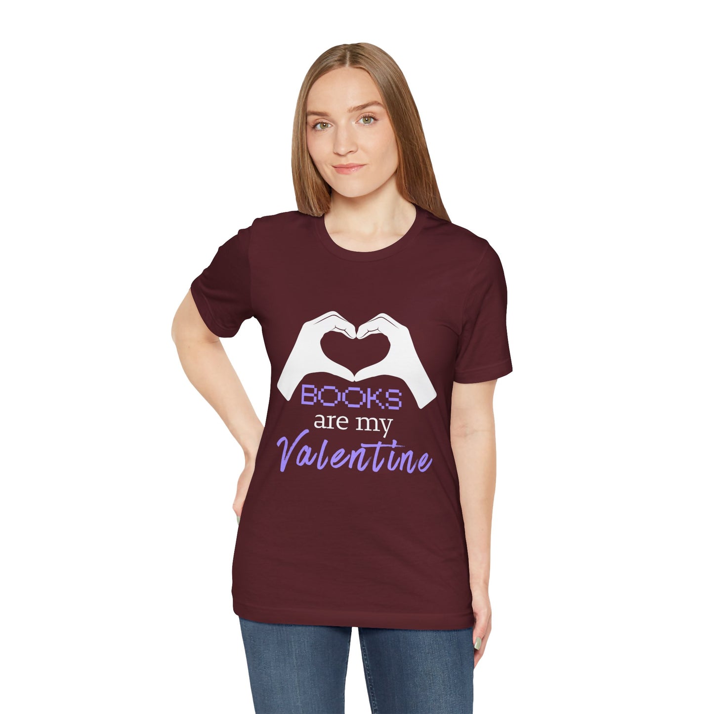Woman wearing a maroon t-shirt with 'Books are my Valentine' design on two hands making a heart shape 