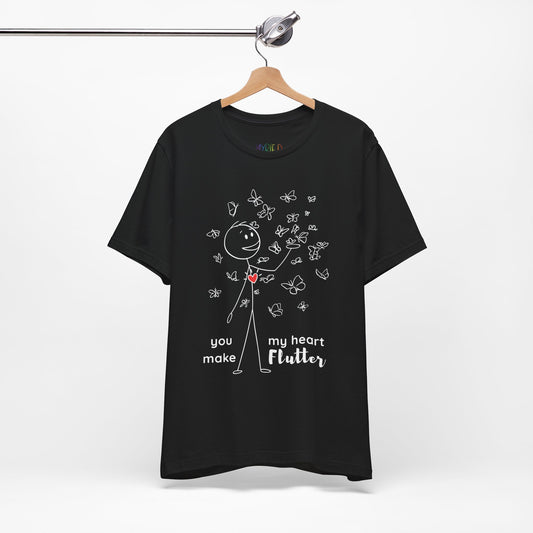 Black t-shirt with a stick figure surrounded by butterflies and a red heart beating on his chest, text 'You Make My Heart Flutter'