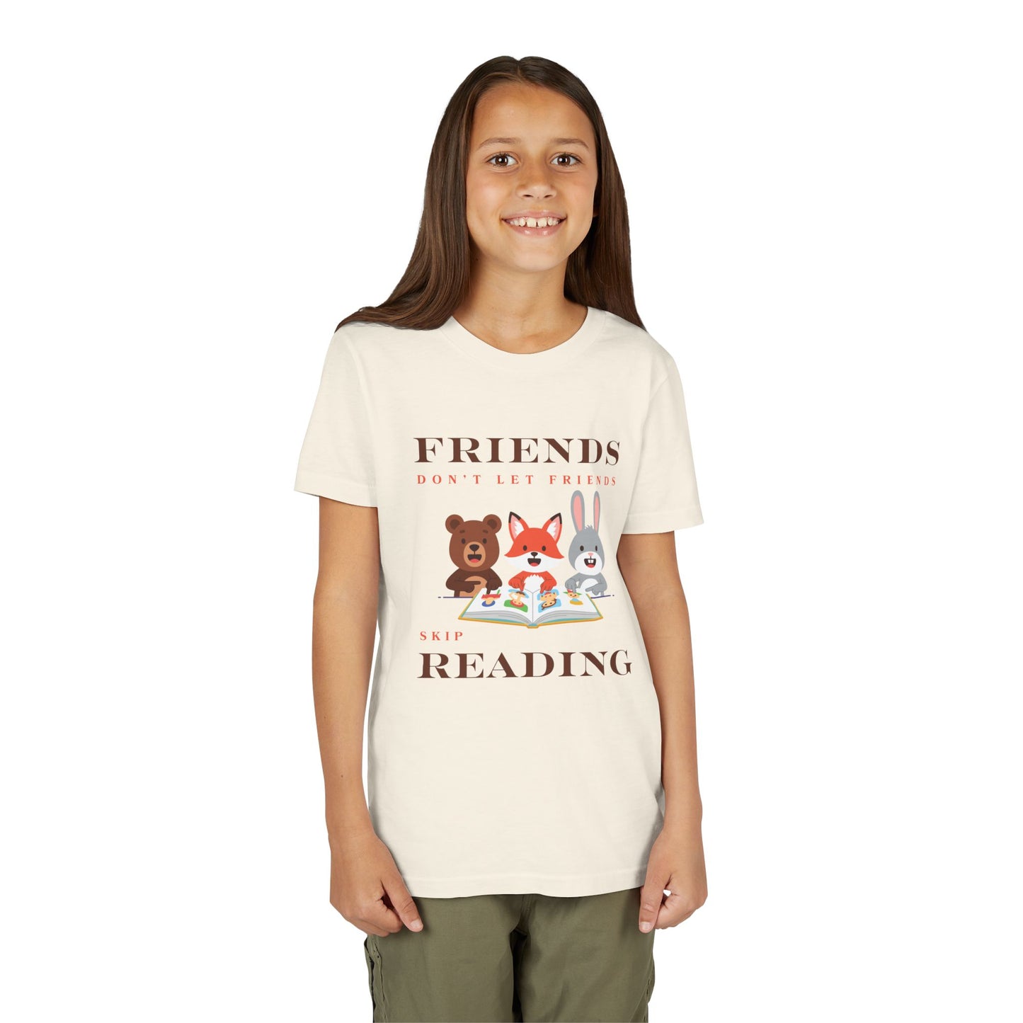 Girl wearing a beige t-shirt with cartoon animals reading a book and text 'Friends don't let friends skip reading' 