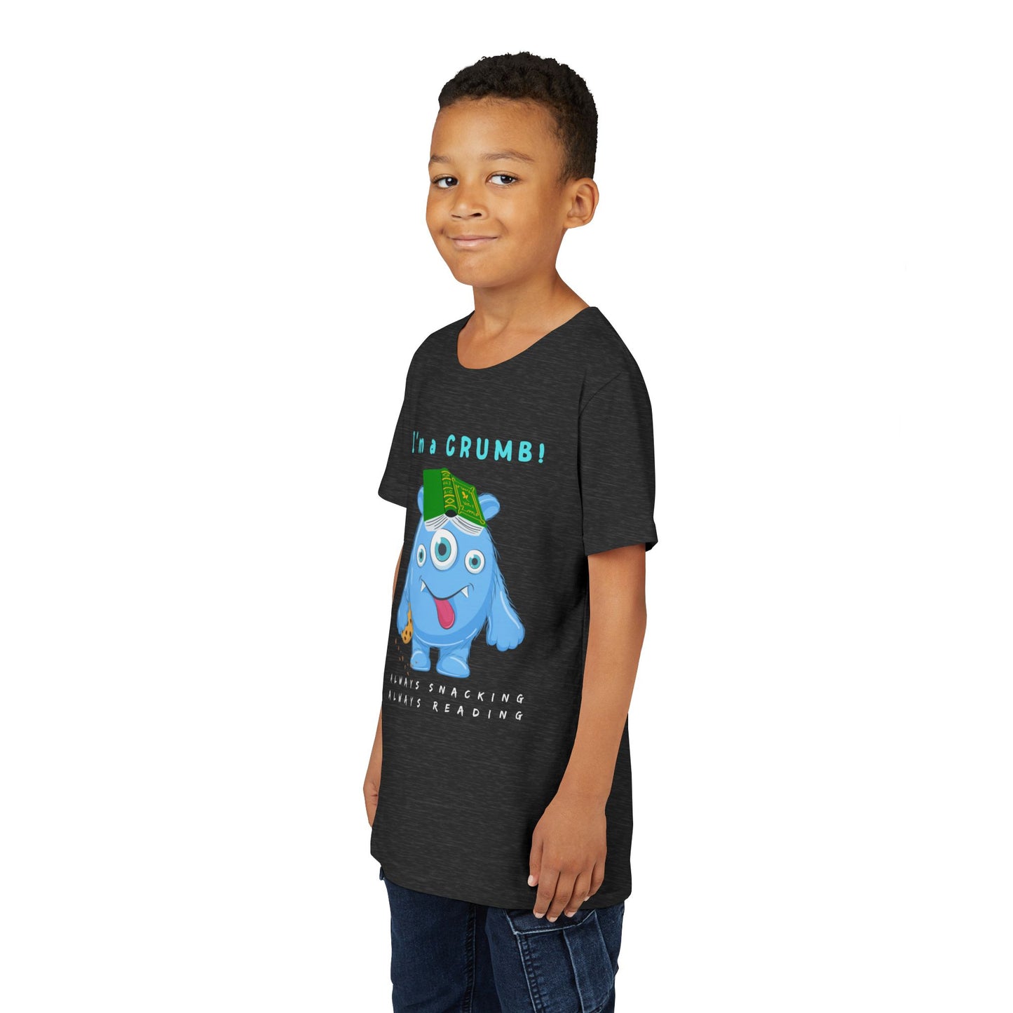 Boy wearing a dark t-shirt with a cartoon blue monster holding a book and text 'I'm a CRUMB!'