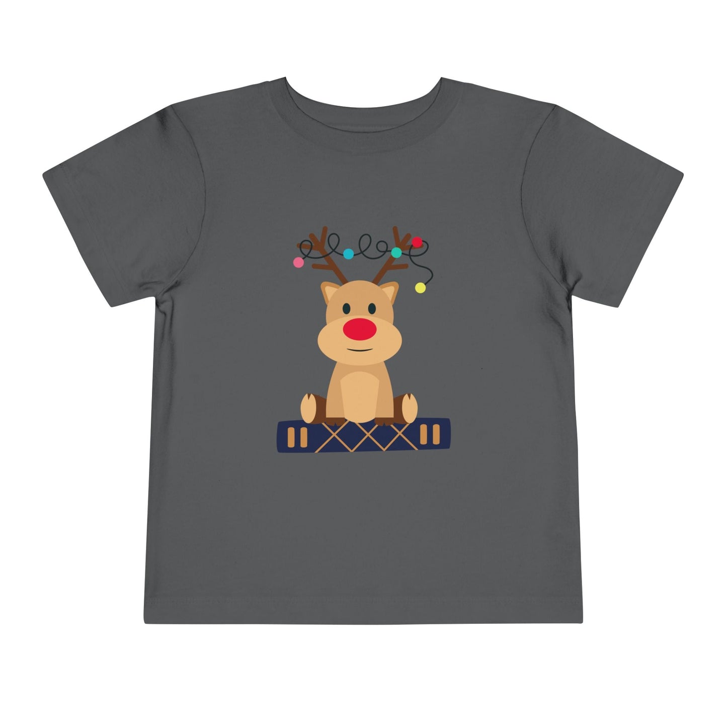 Gray toddler t-shirt with a baby reindeer sitting on a book, a string of Christmas lights in it's antlers, on a white background