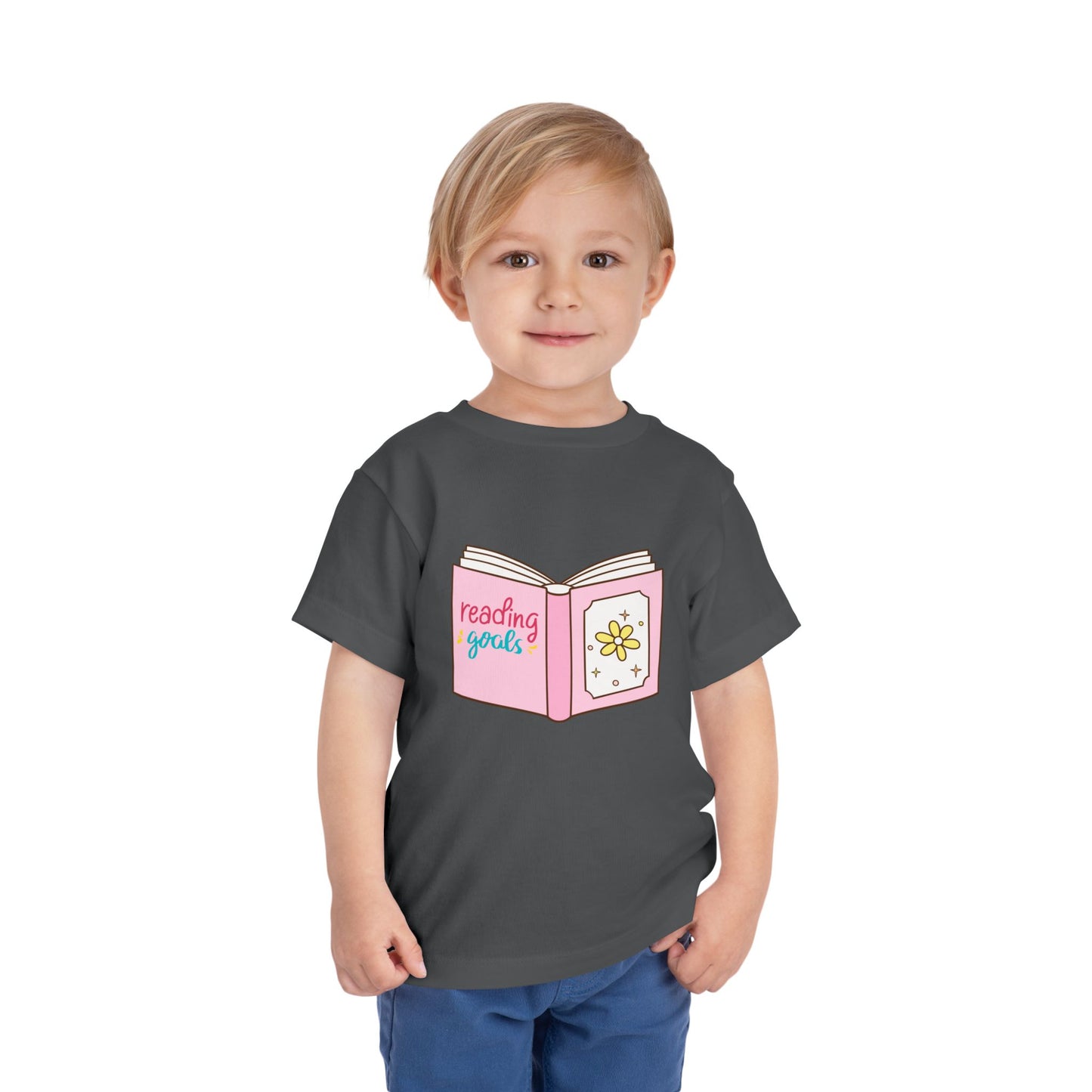 Child wearing a gray toddler t-shirt with a pink book graphic and 'reading goals' text 