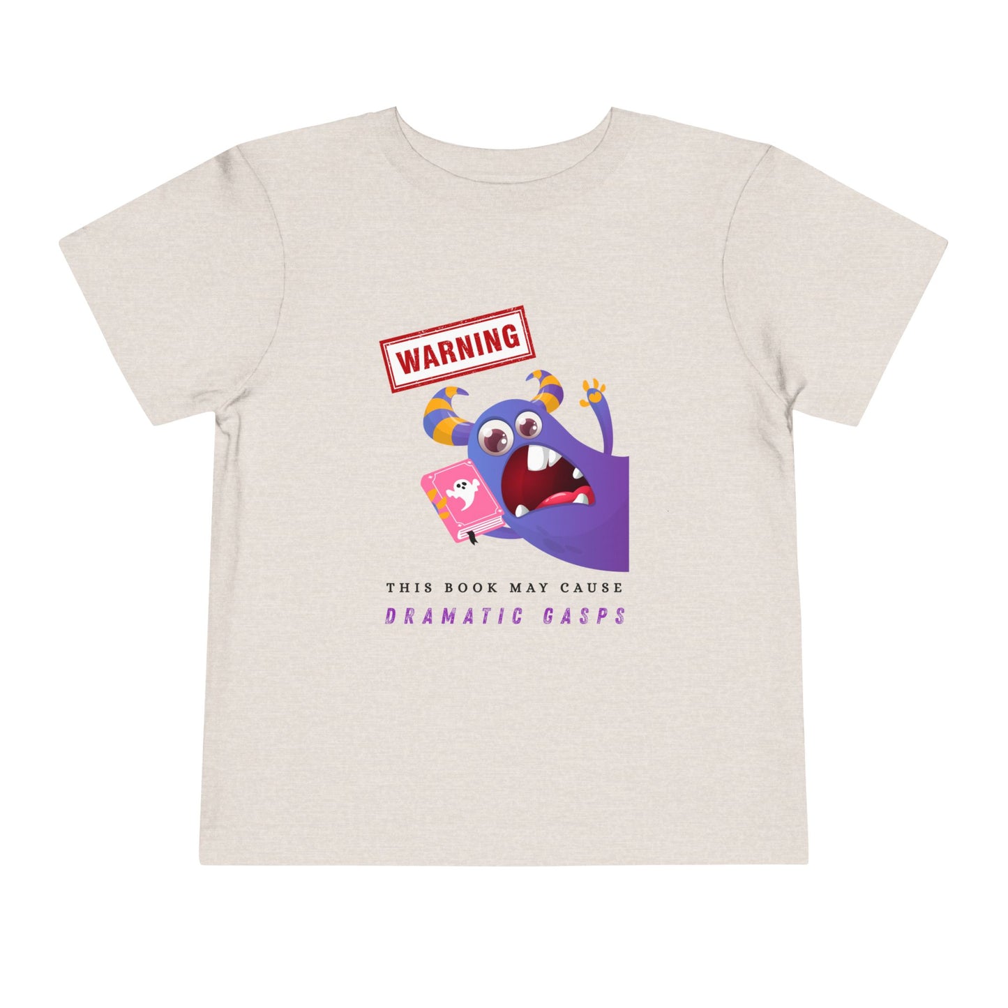 Beige toddler t-shirt with an open mouth purple monster holding a pink book and a WARNING ' This Book May Cause Dramatic Gasps'