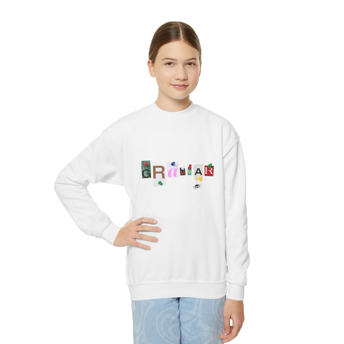 Girl wearing a white sweatshirt with colorful letters tacked up to spell 'Grammar'