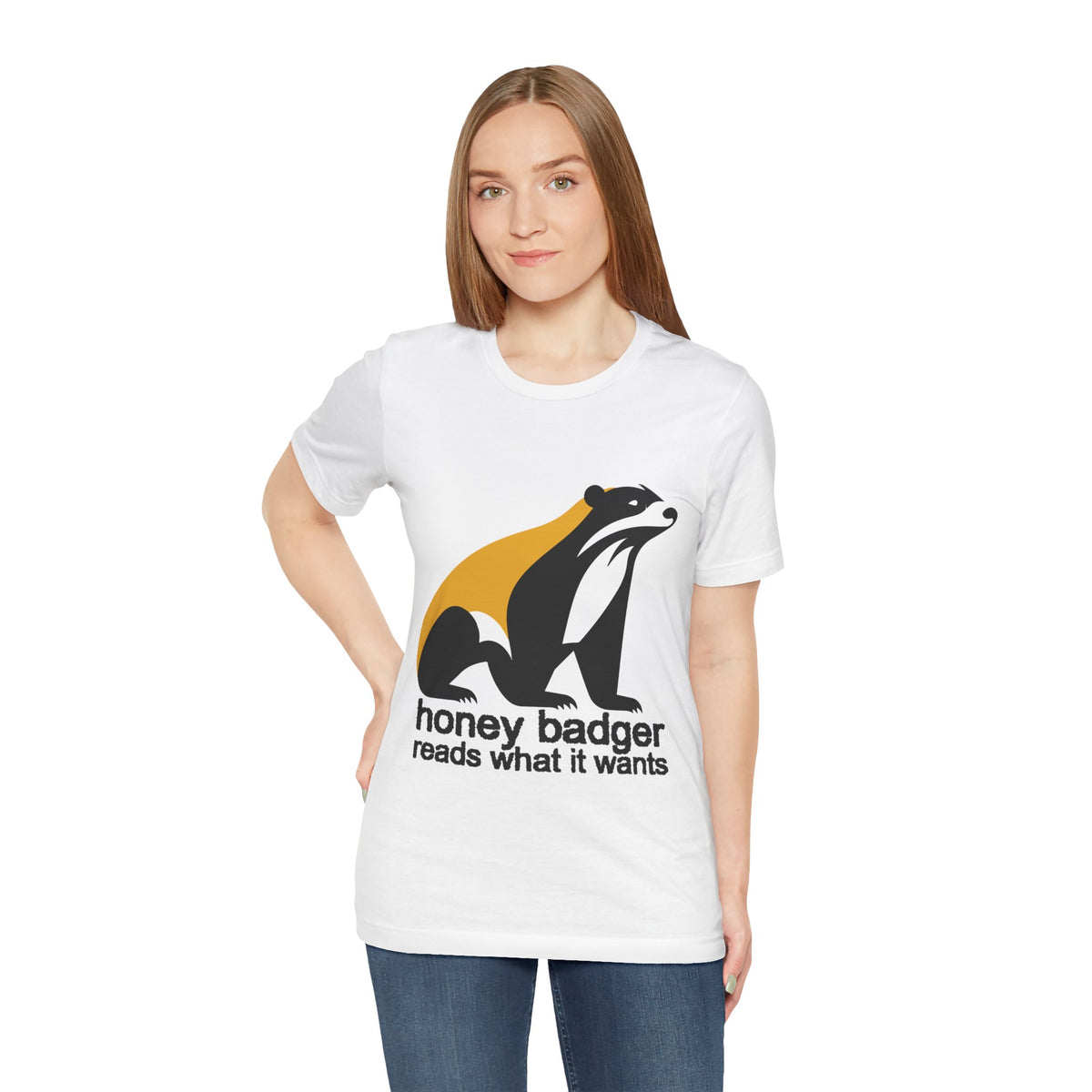 Woman wearing a white t-shirt featuring a large black yellow and white badger with text "honey badger reads what it wants"