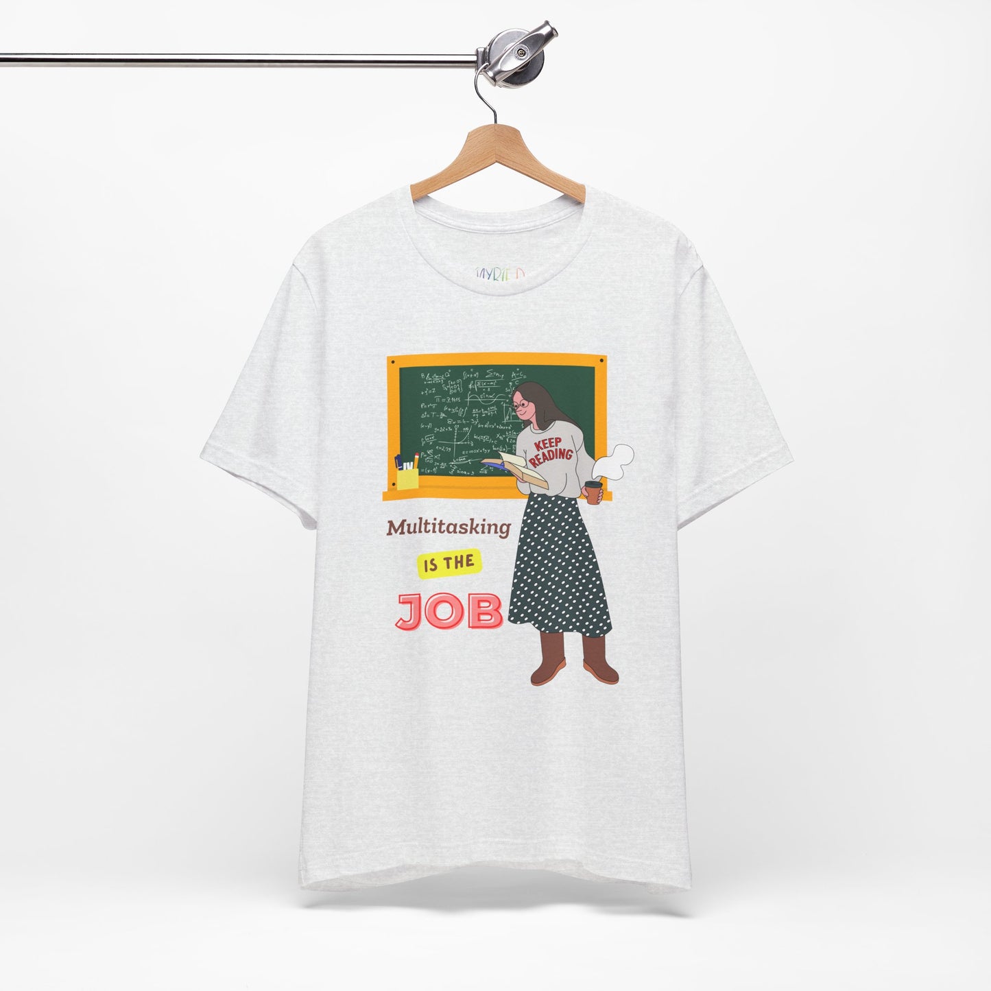 Light gray t-shirt with a graphic design of a woman at a chalkboard, an open book in one hand and steaming coffee in the other, text 'Multitasking is the Job' 
