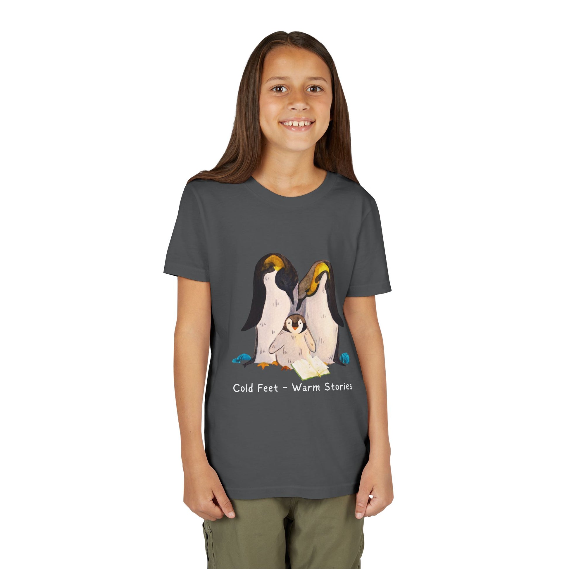 Girl wearing a gray t-shirt with a penguin family, open book and text 'Cold Feet - Warm Stories'
