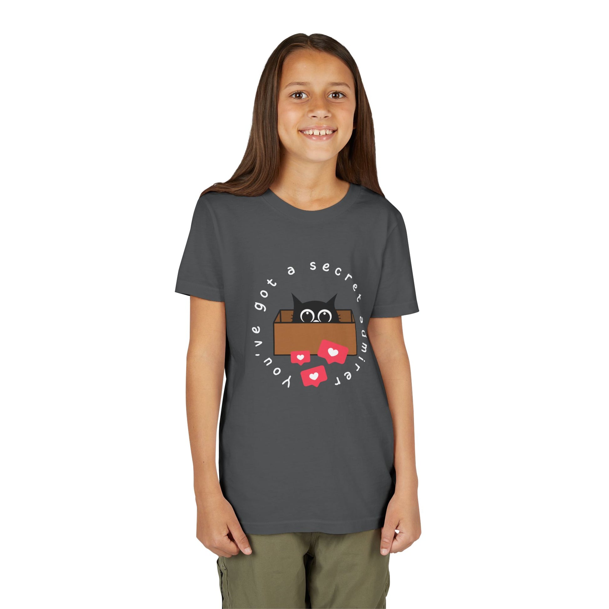 Girl wearing a gray t-shirt with a graphic of a cat peeking out of a box, heart social media bubbles and text 'You've Got A Secret Admirer' 