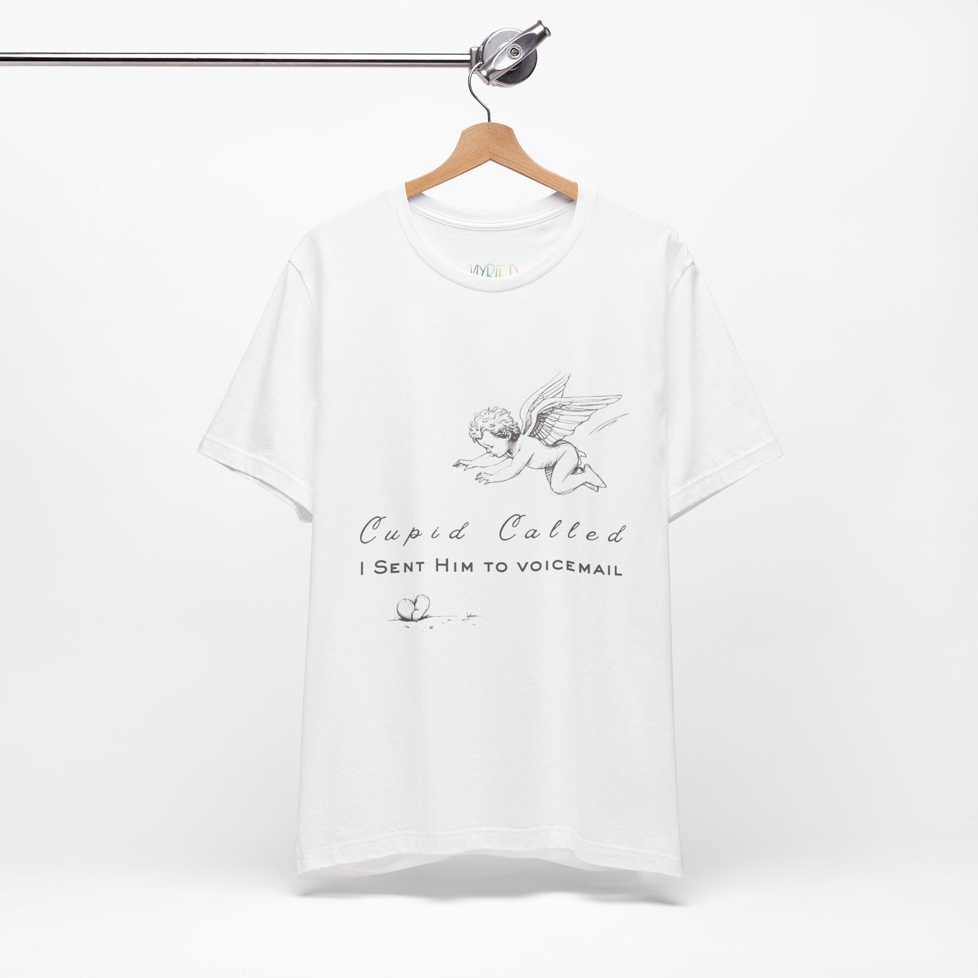 White t-shirt with cupid graphic design, a broken heart on the floor and text 'Cupid Called. I Sent Him To Voicemail.'