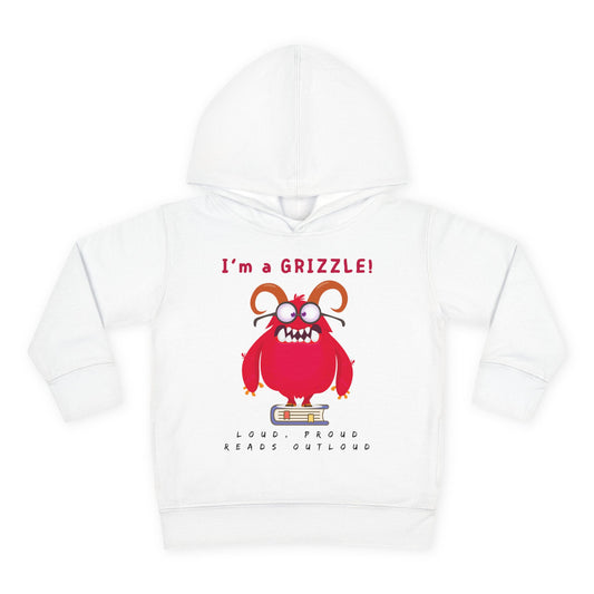 Red cartoon monster with a big grin and arms raised in excitement, holding an open book with the words “I’m a Grizzle” above — printed on a toddler hoodie.