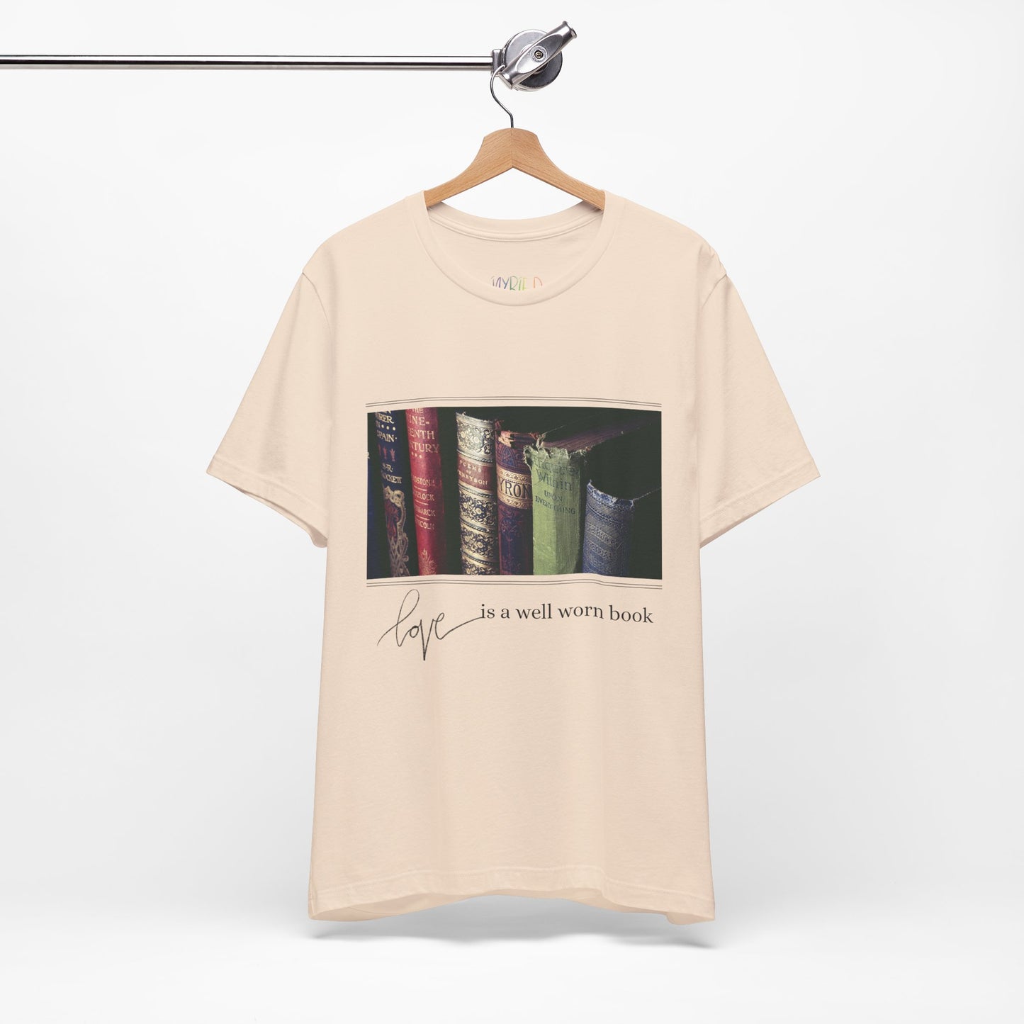 Beige t-shirt with a row of old books and text 'Love Is A Well Worn Book'