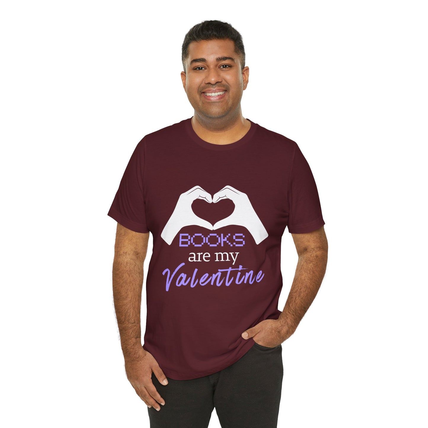 Man wearing a maroon t-shirt with 'Books are my Valentine' design on two hands making a heart shape 