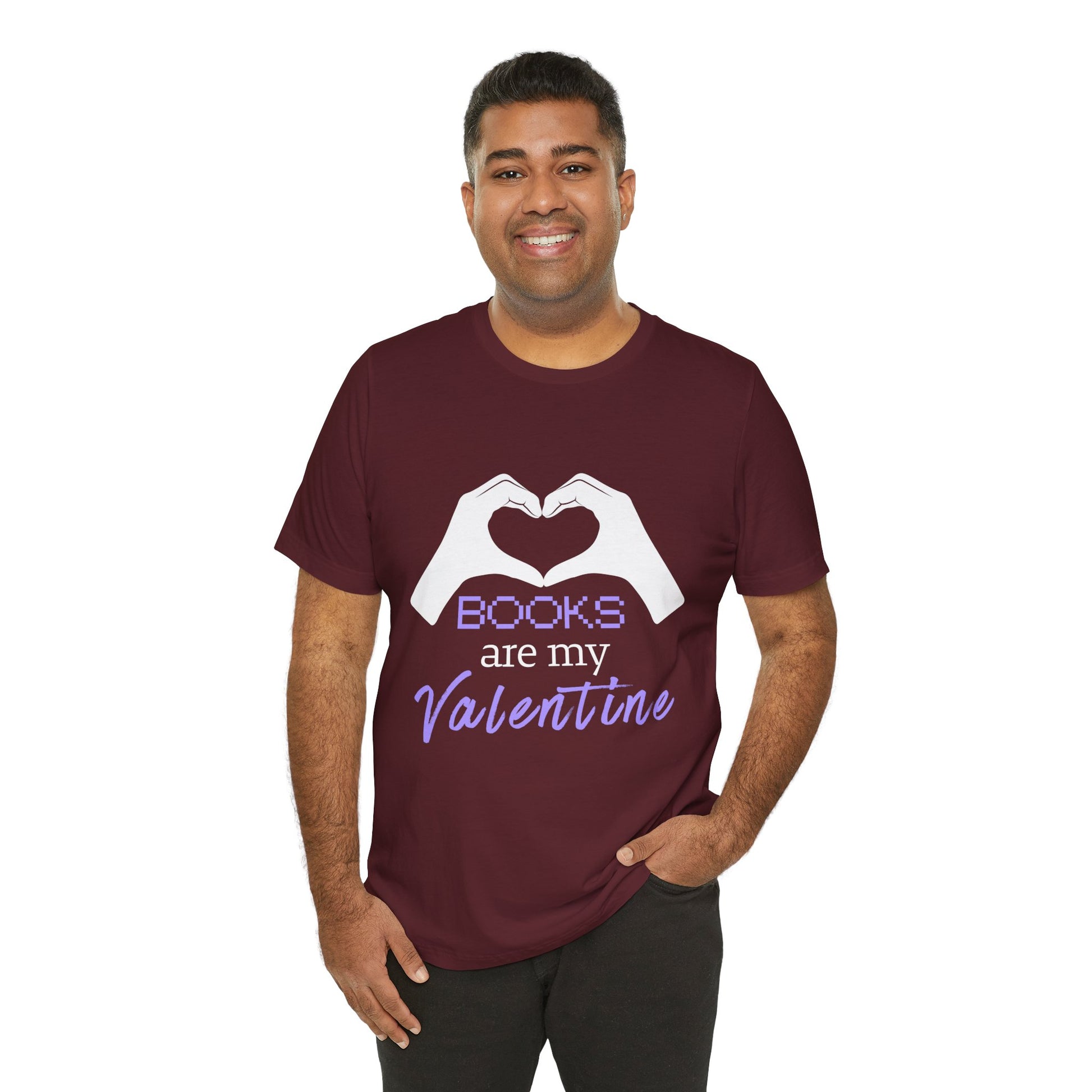 Man wearing a maroon t-shirt with 'Books are my Valentine' design on two hands making a heart shape 