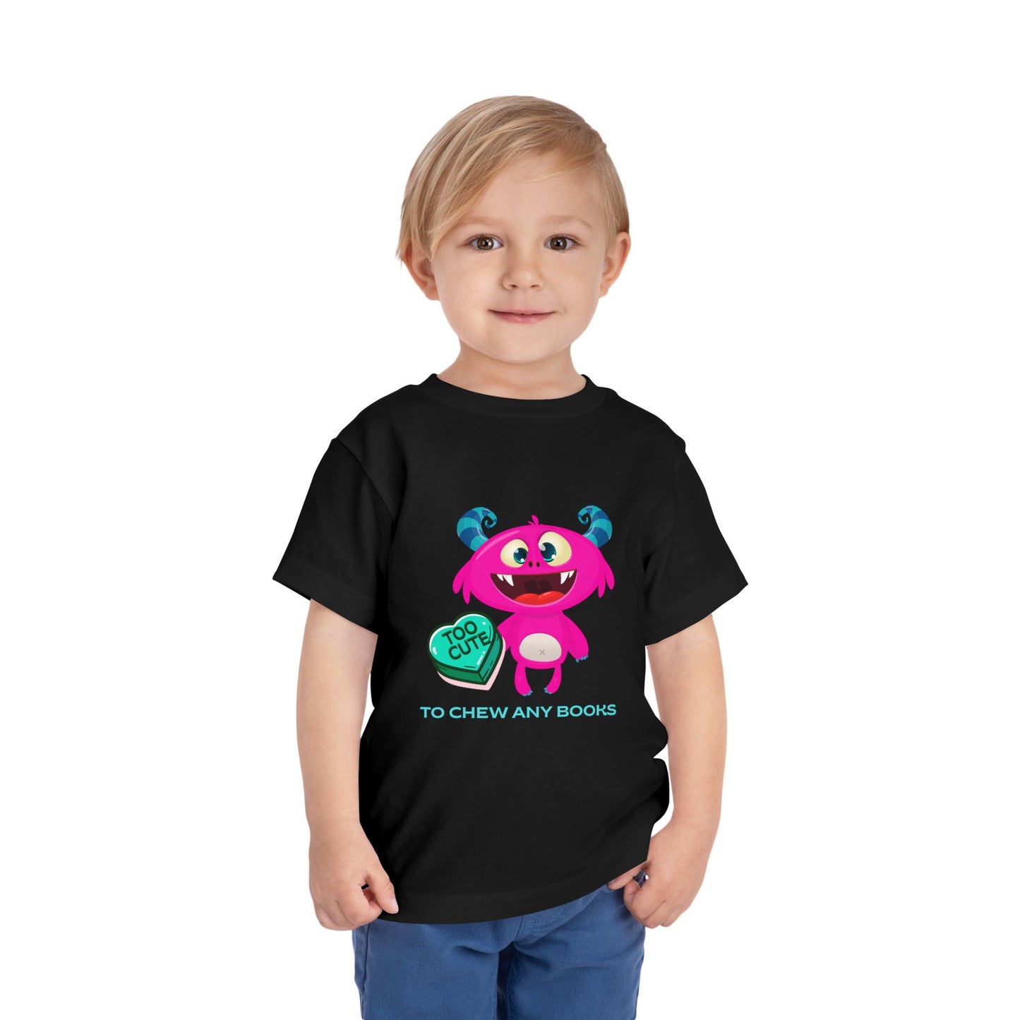 Child wearing a black toddler t-shirt with a cartoon gapped tooth monster, a turquoise heart with text 'too cute' and additional text 'to chew any books'