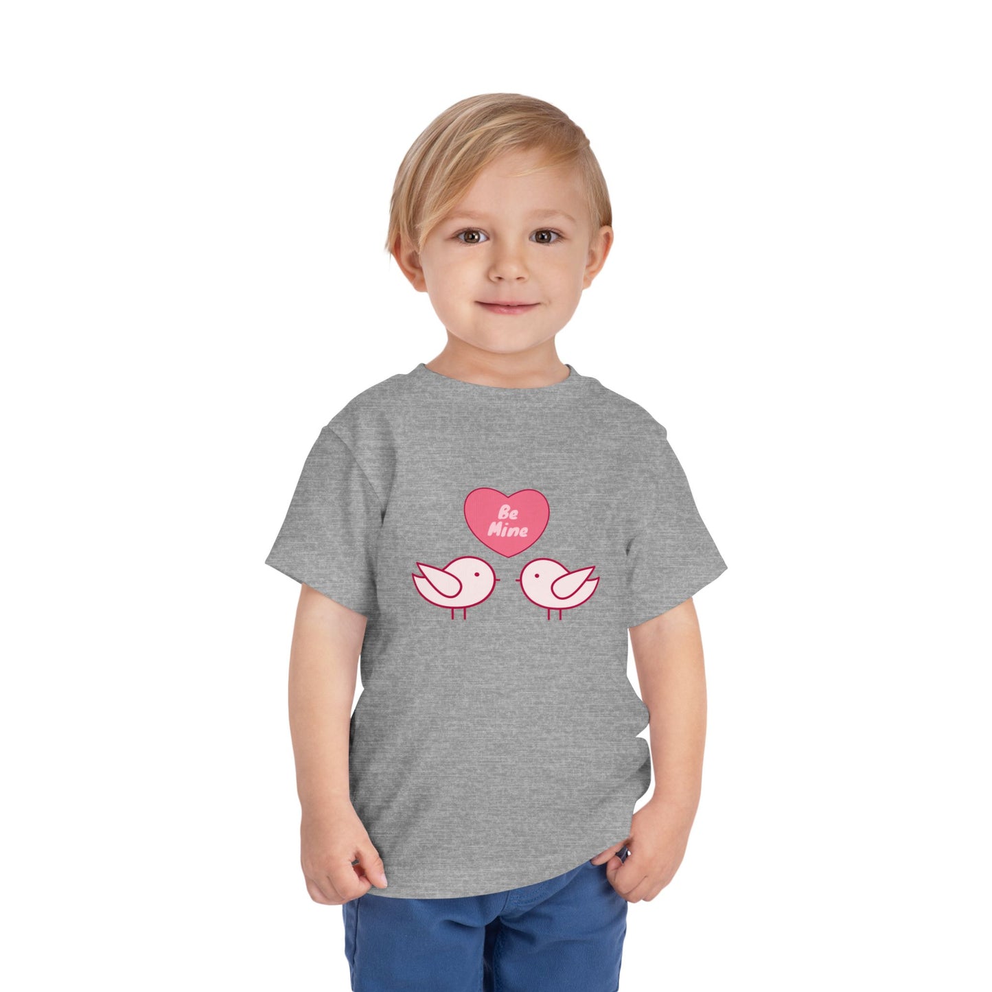 Child wearing a gray toddler t-shirt with pink heart, two pink birds and 'Be Mine' text 