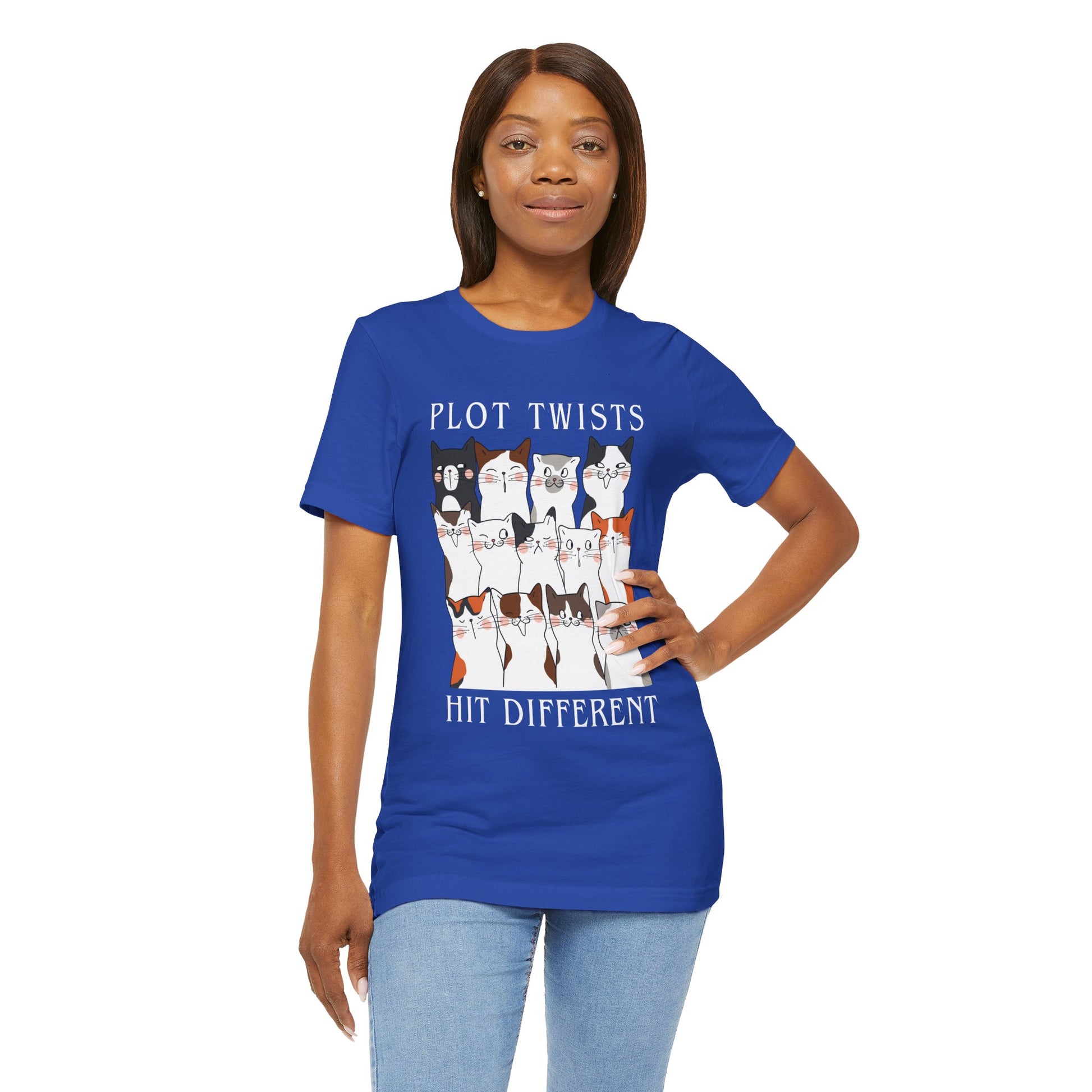 Woman wearing a blue t-shirt with rows of cats making different faces and text 'Plot Twists Hit Different' 