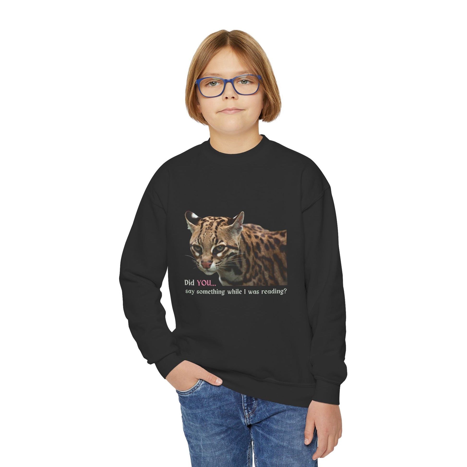 Boy wearing a black sweatshirt with a cat (ocelot) graphic and text 'Did you...say something while I was reading?'