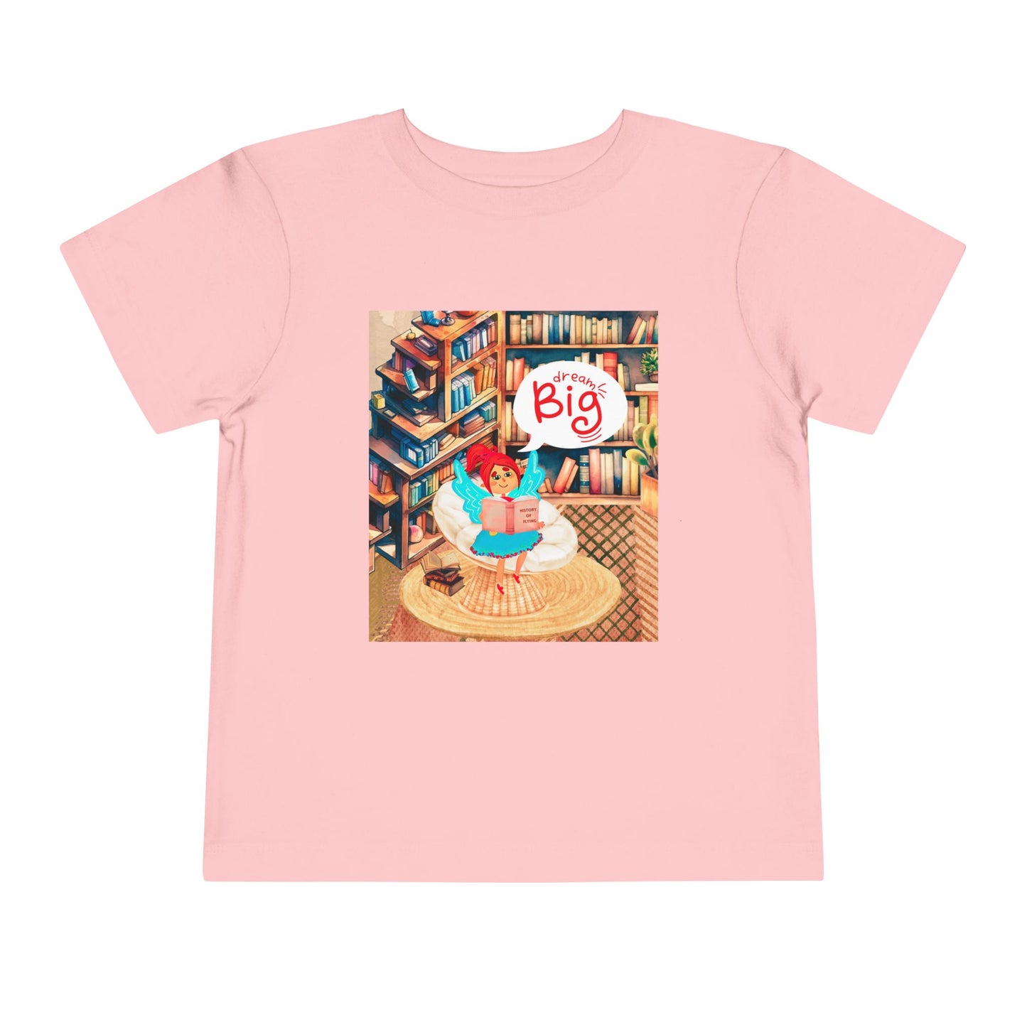 Pink t-shirt with a colorful library graphic of a fairy reading a book and thought bubble text 'Dream Big'