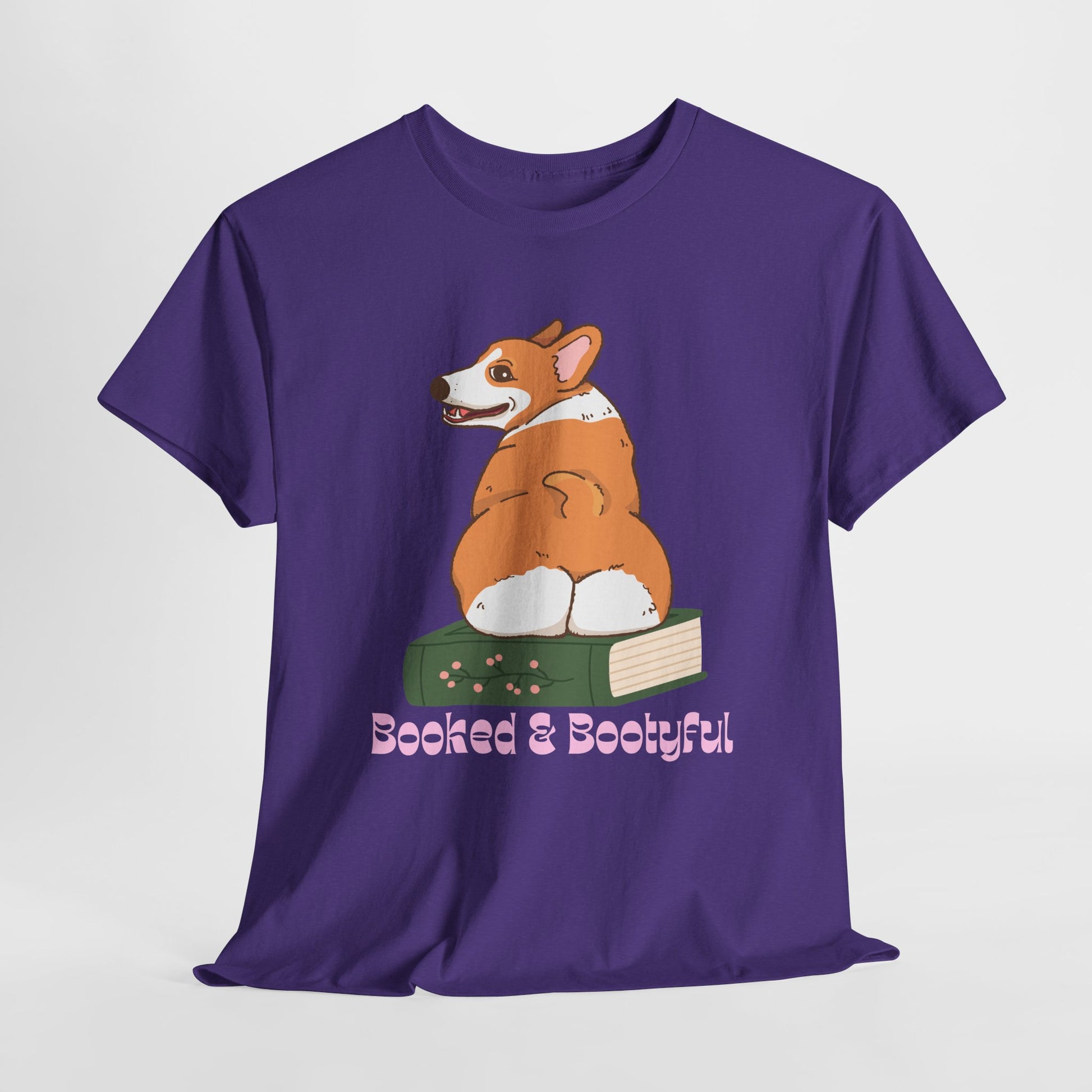 Purple t-shirt with a Corgi dog, sitting on a book with his back side facing out, looking over its shoulder and text 'Booked & Bootyful'