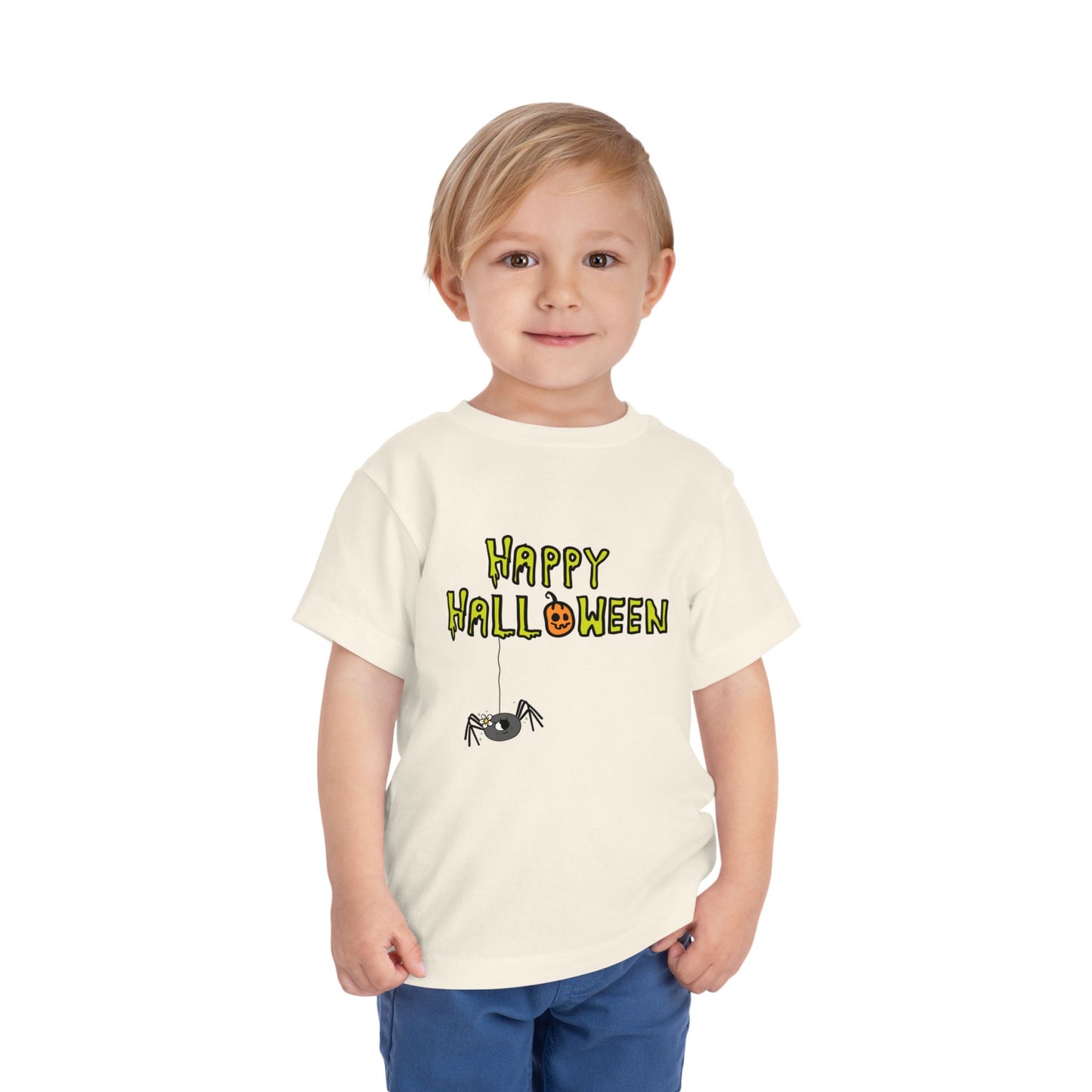 Toddler wearing a beige t-shirt with creepy type text 'Happy Halloween' and a dangling spider 