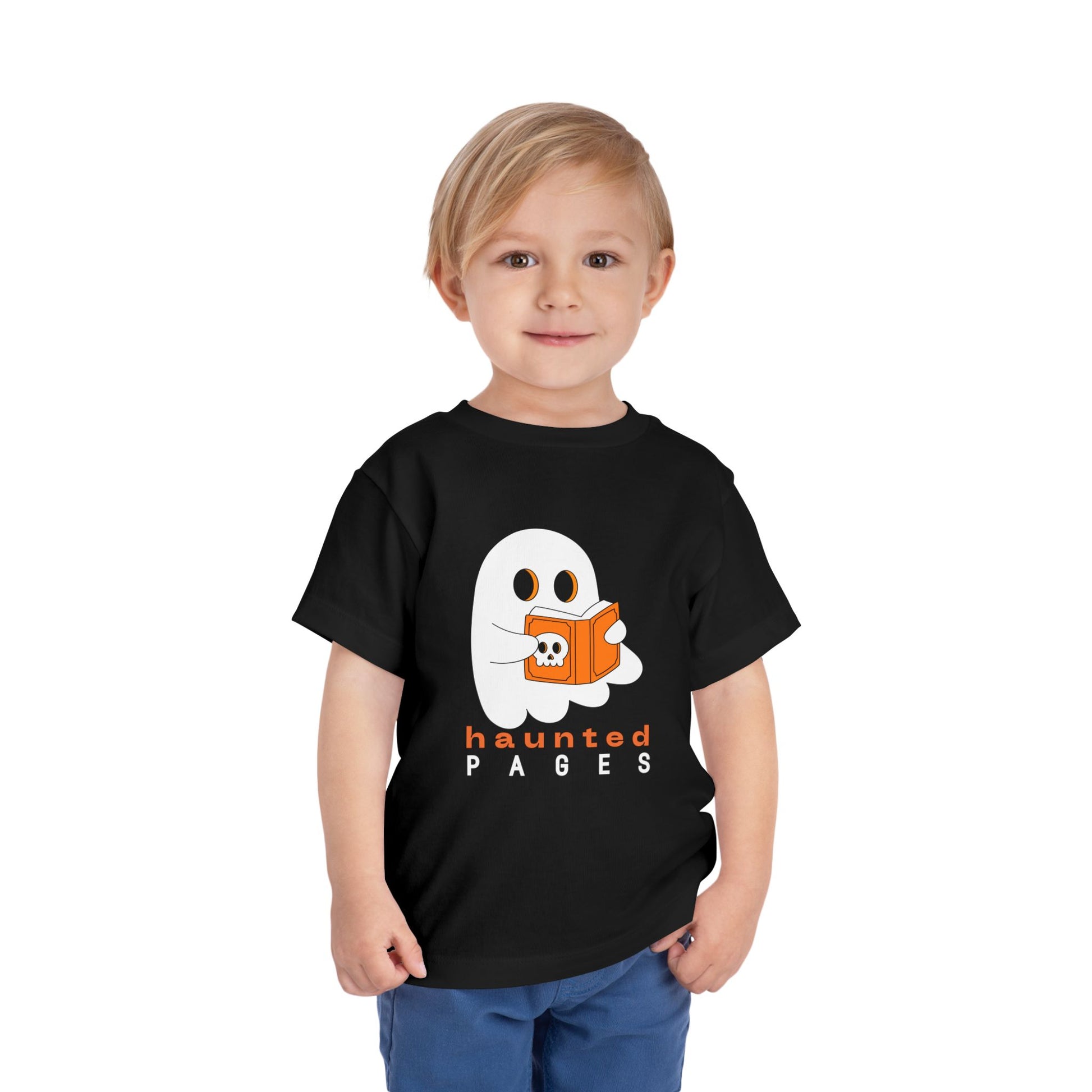 Child wearing a black toddler t-shirt with a ghost reading a scary book and 'haunted pages' text on a white background