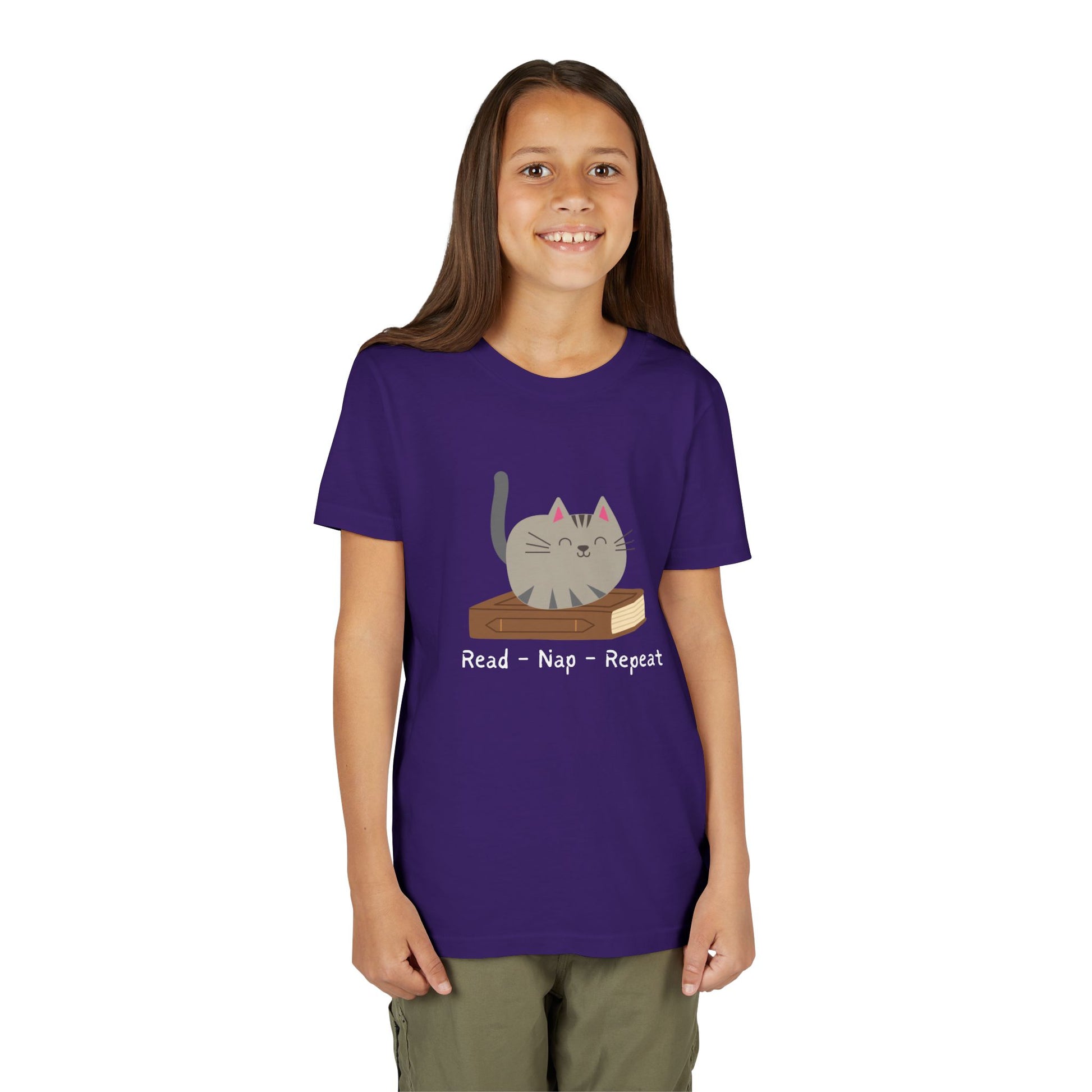 Girl wearing a purple t-shirt with a cat sitting on a book and text 'Read - Nap - Repeat' 