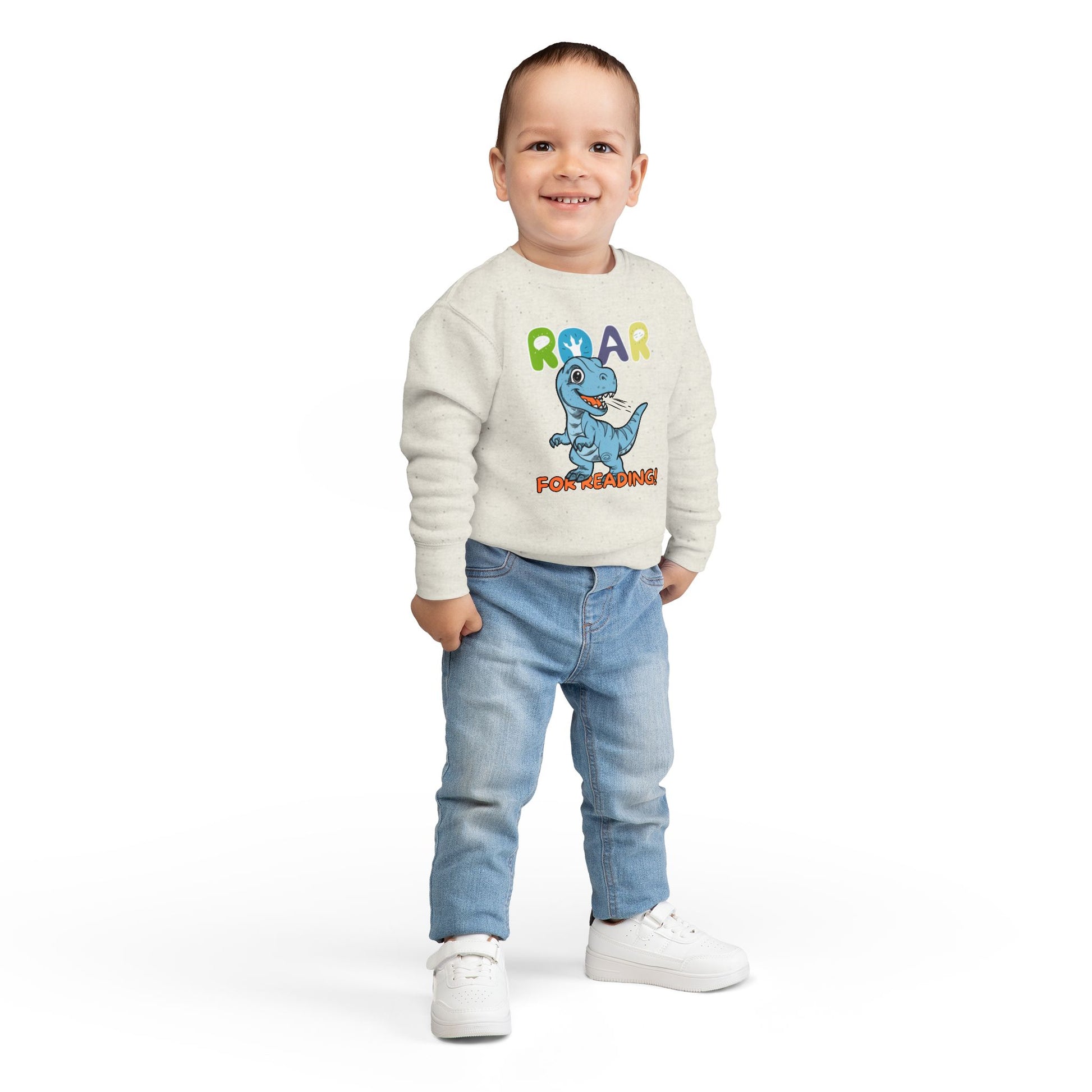 Boy wearing a beige toddler sweatshirt with a dinosaur graphic and 'Roar for Reading!' text 