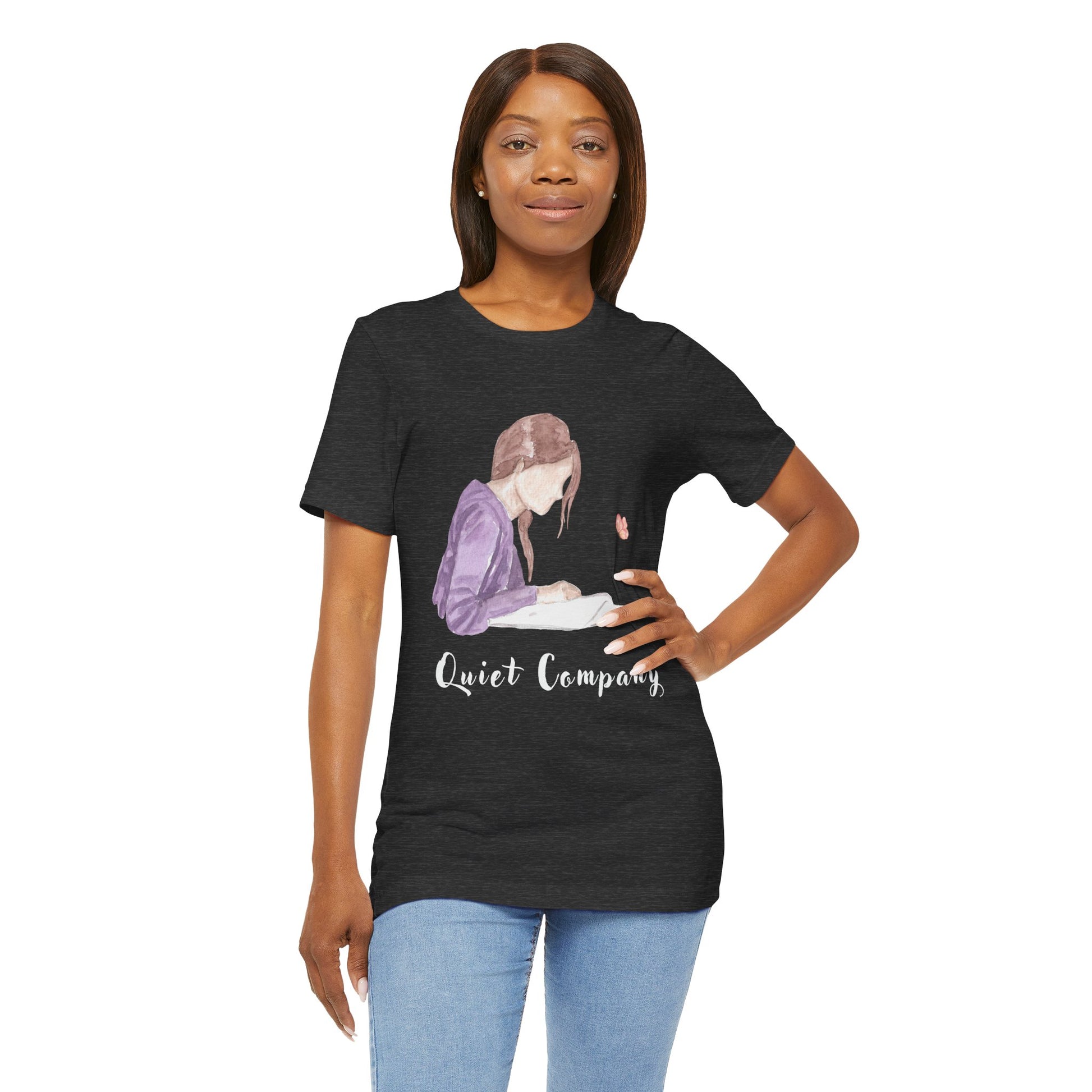 Woman wearing a dark gray t-shirt with a graphic of a girl reading a book and the text 'Quiet Company' 