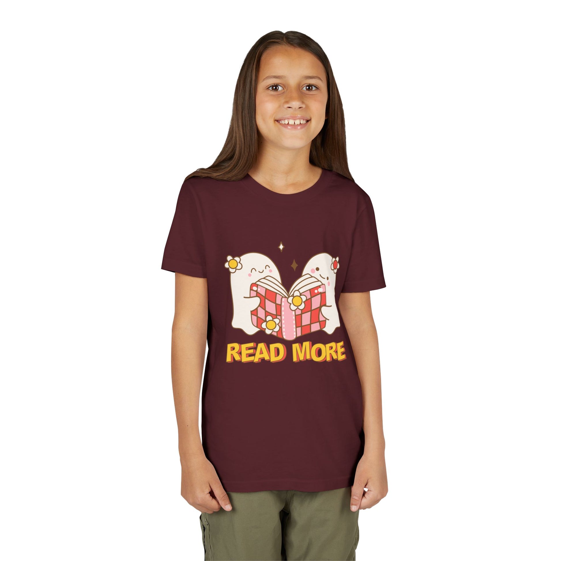 Child wearing a maroon t-shirt with cartoon ghosts reading a shared book and 'Read More' text 
