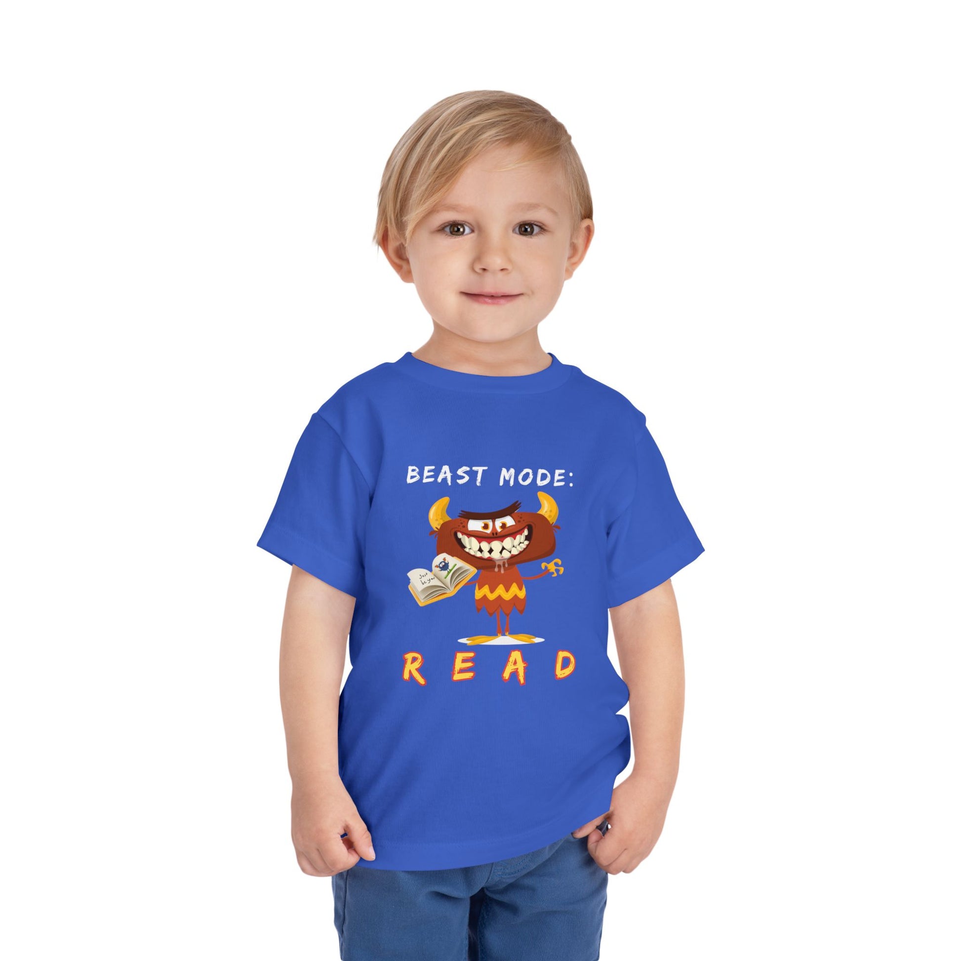 Child wearing a blue toddler t-shirt with a drooling cartoon monster holding a book and text 'Beast Mode: Read' 