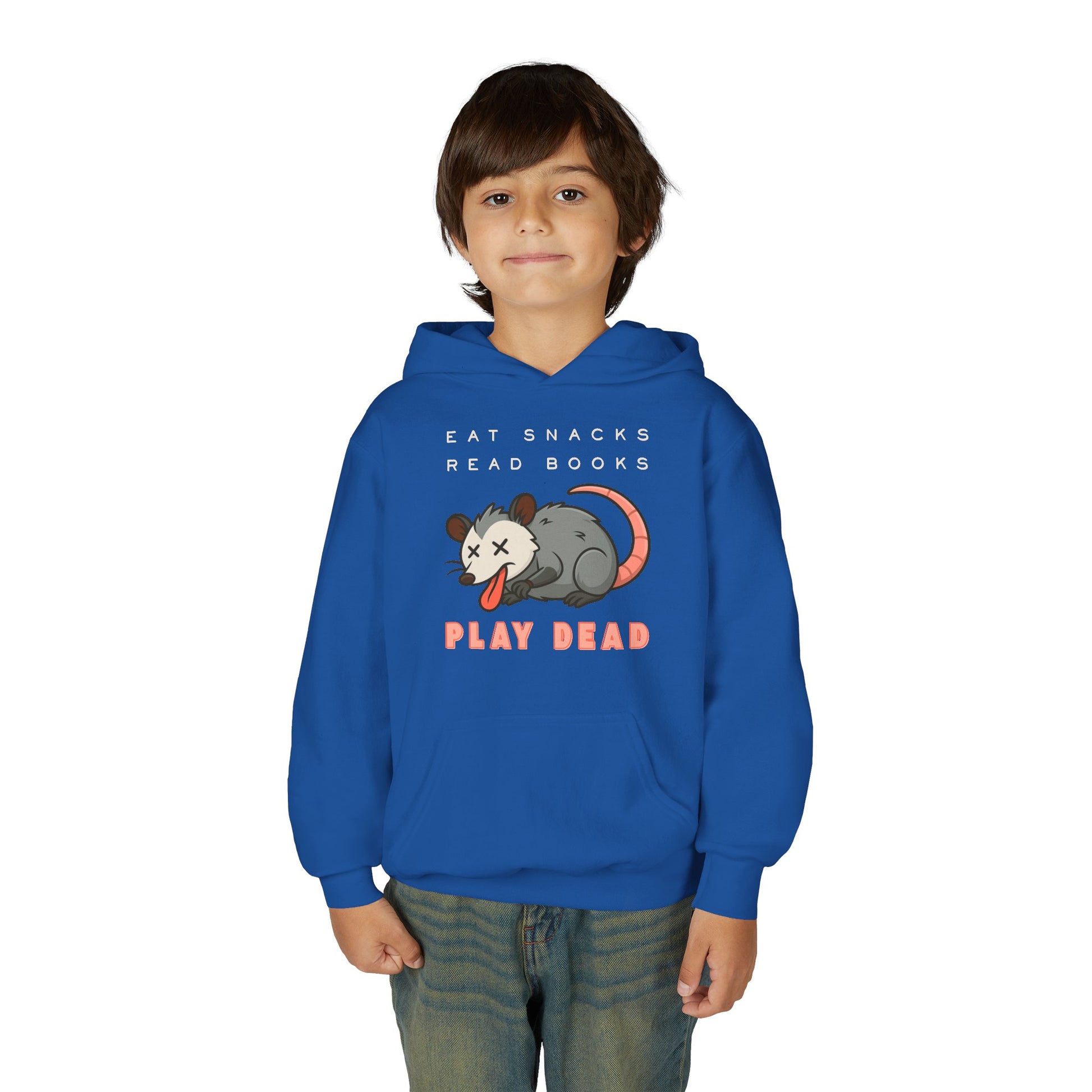 Boy wearing a blue hoodie with a graphic of a opossum and text 'Eat Snacks. Read Books. Play Dead'