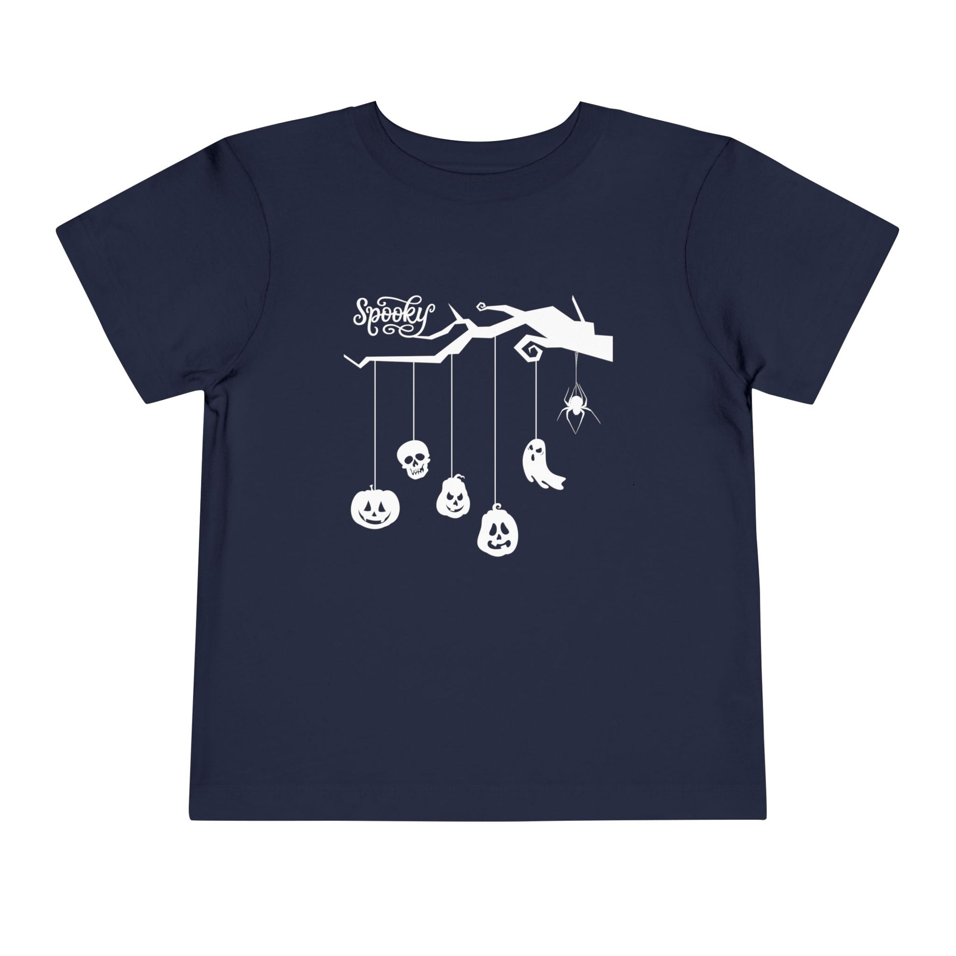Navy blue t-shirt with white Halloween-themed tree branch and dangling charms (pumpkins, skull, ghost, spider), white text 'SPOOKY' 