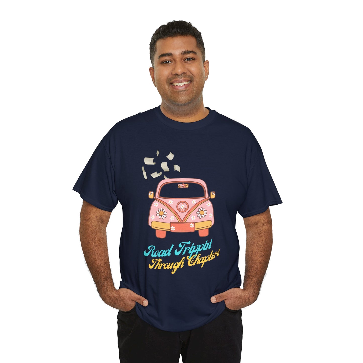 Man wearing a navy blue t-shirt with a retro pink car , pages flying out the windows and text 'Road Tripping Through Chapters' 