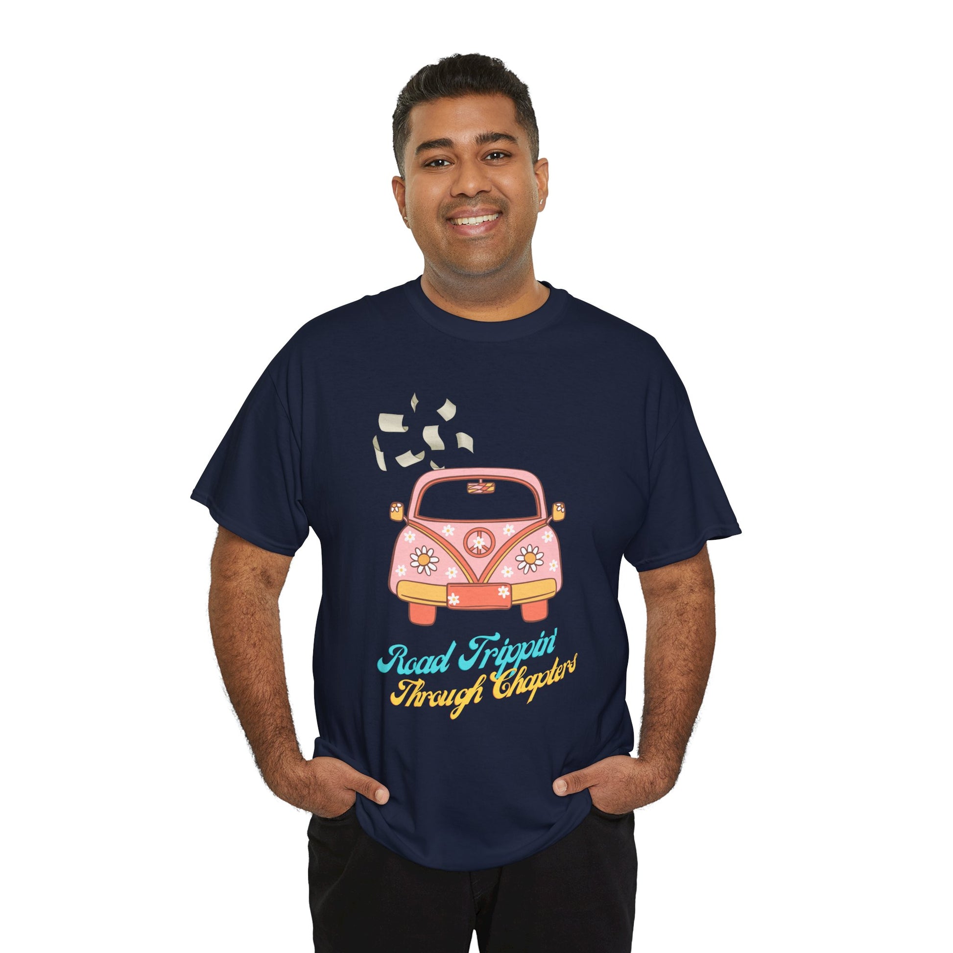 Man wearing a navy blue t-shirt with a retro pink car , pages flying out the windows and text 'Road Tripping Through Chapters' 